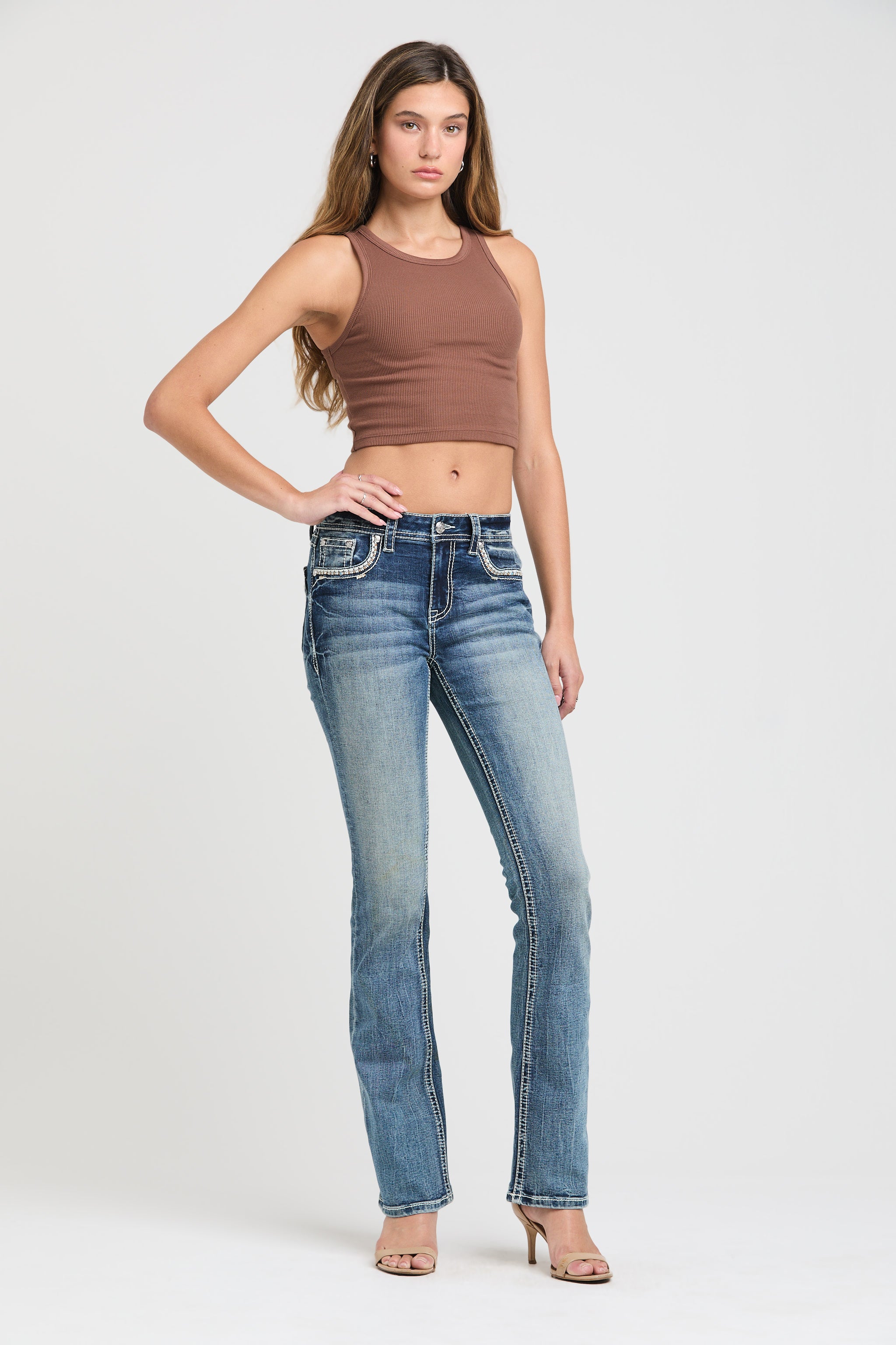 Grace in LA womens bootcut jeans in a medium styled with a brown ribbed crop tank top to highlight the slim fit and crystal-embellished pockets.