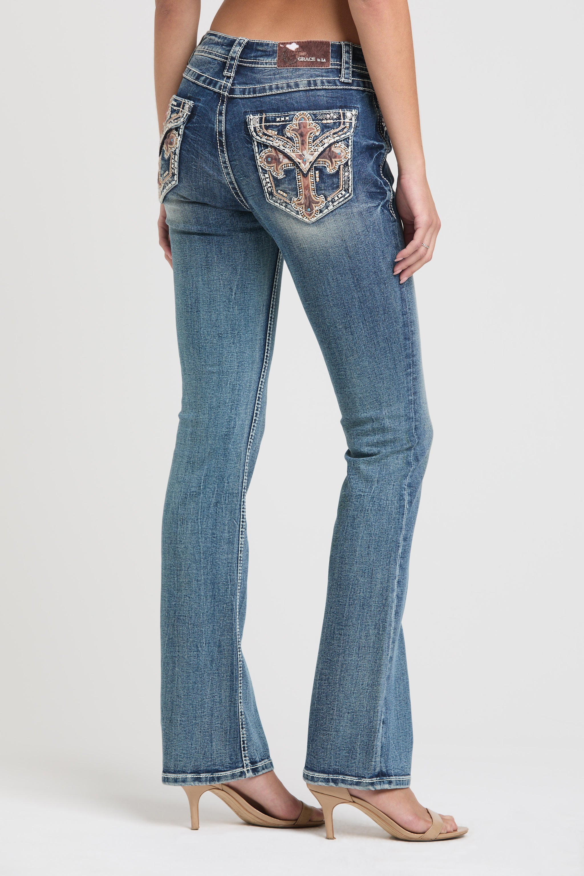 Grace in LA womens bootcut jeans in a medium featuring a side-rear view with crystal-embellished longhorn embroidery on the back pocket.