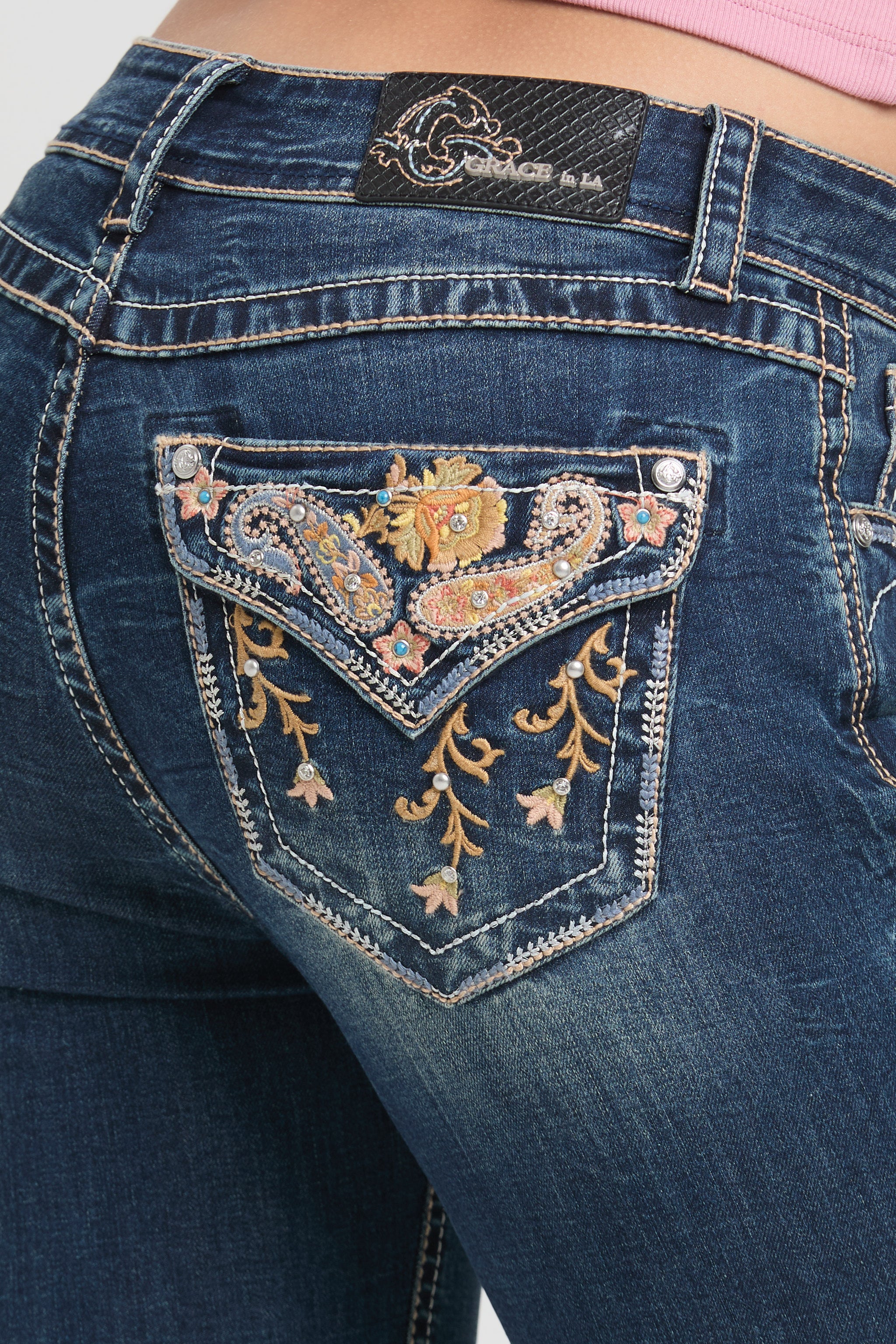 Grace in LA womens bootcut jeans in rear view showing symmetrical colorful paisley and floral vine pocket embroidery.