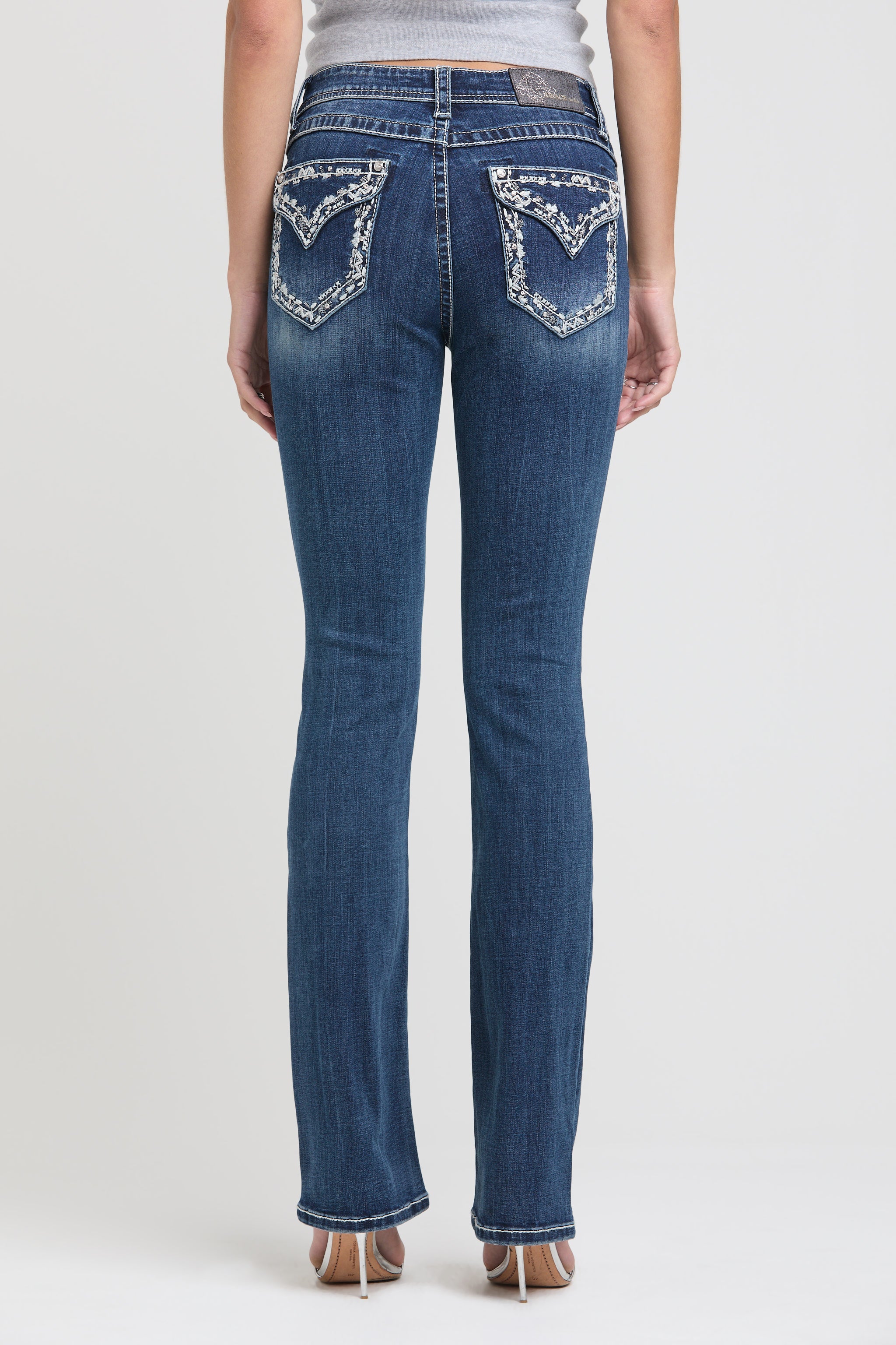 Womens bootcut jeans Rear view of Grace in LA showing symmetrical white floral embroidery on both back pockets.