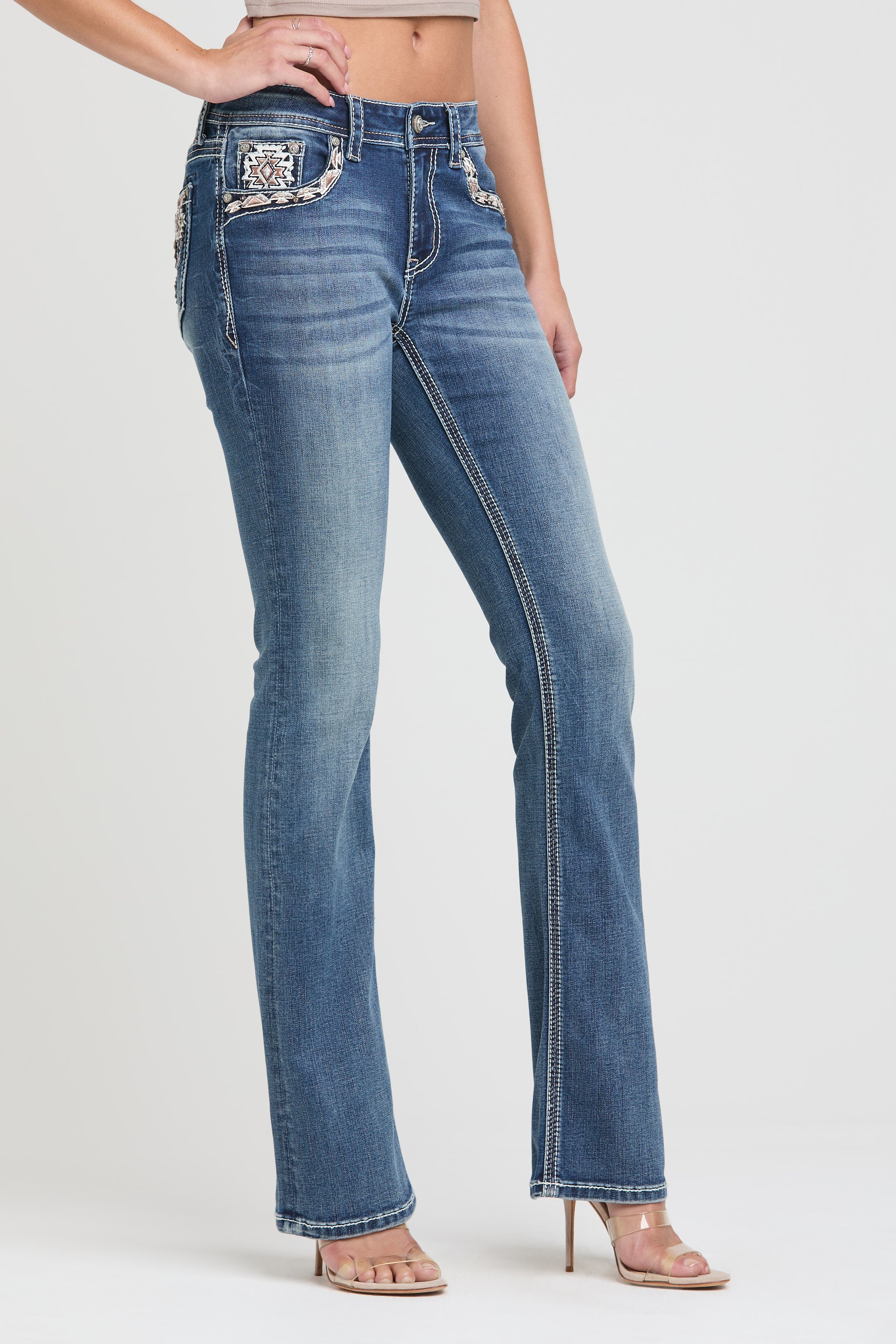 Grace in LA flare jeans for women in a light featuring colorful western embroidery including teepees, feathers, and a dreamcatcher design.