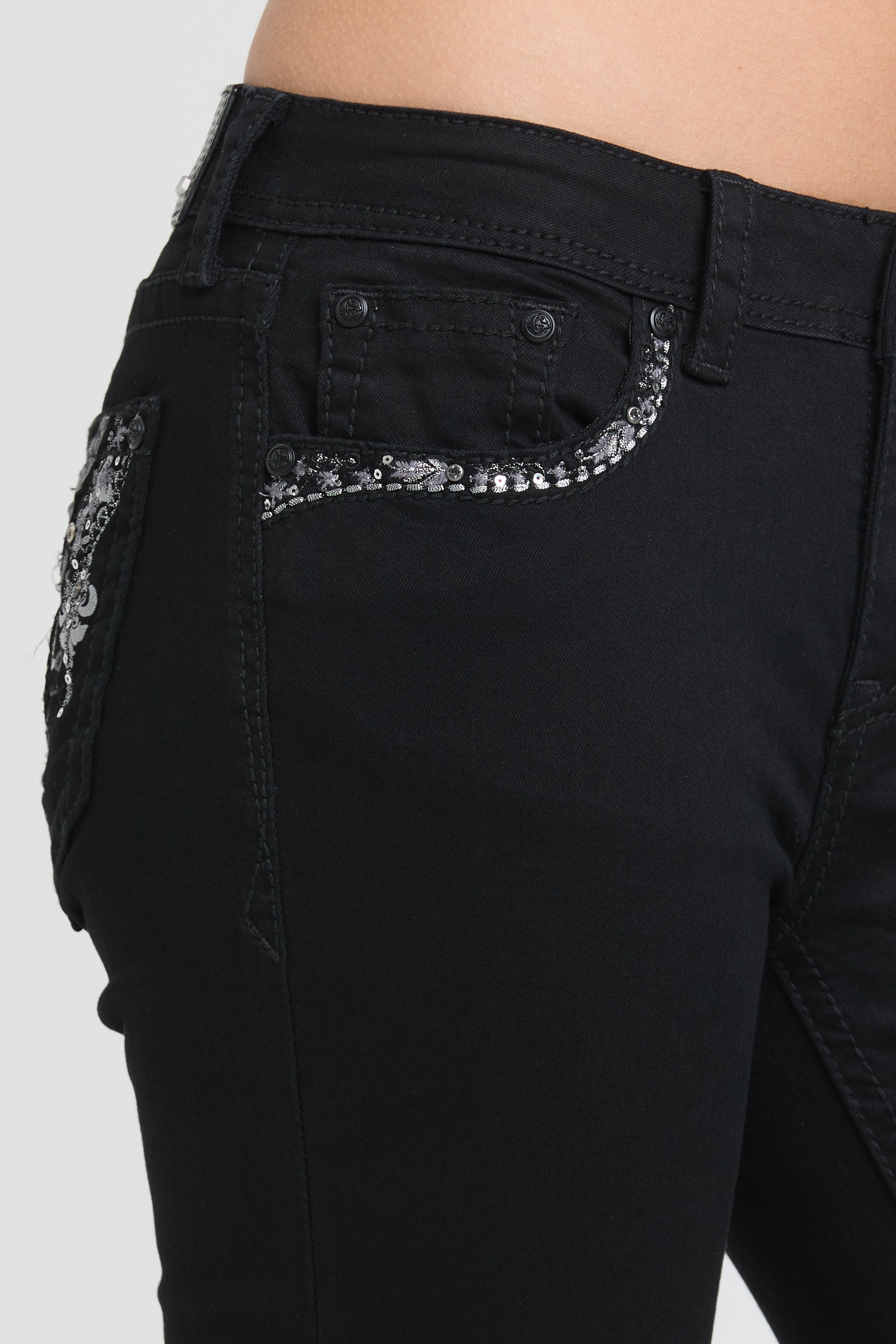 Grace in LA black bootcut jeans featuring a side view of the front pocket detailed with shimmering black and silver sequin trim.