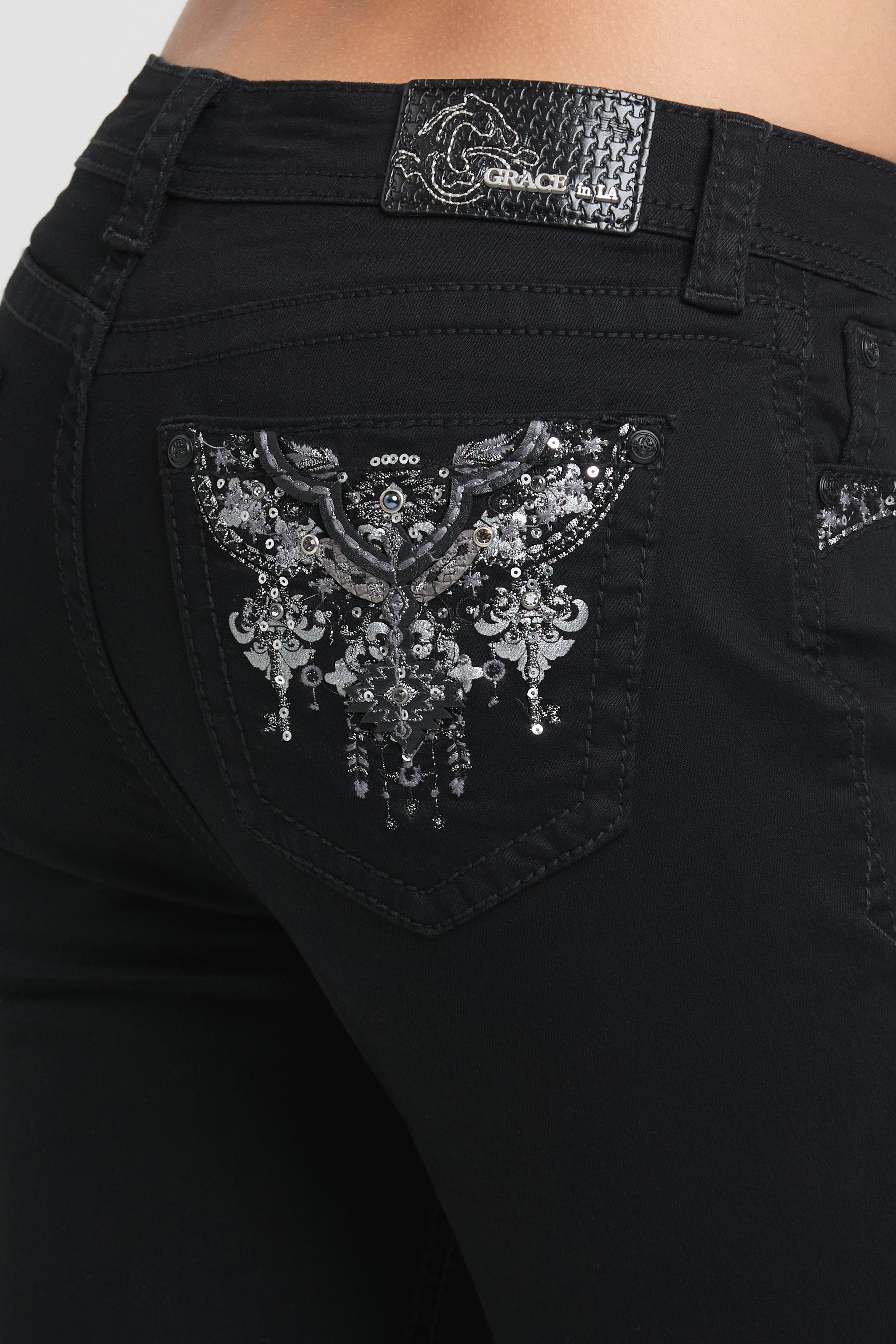 Grace in LA womens bootcut jeans in black featuring a back pocket with intricate silver sequin wing embroidery and crystal chandelier accents.