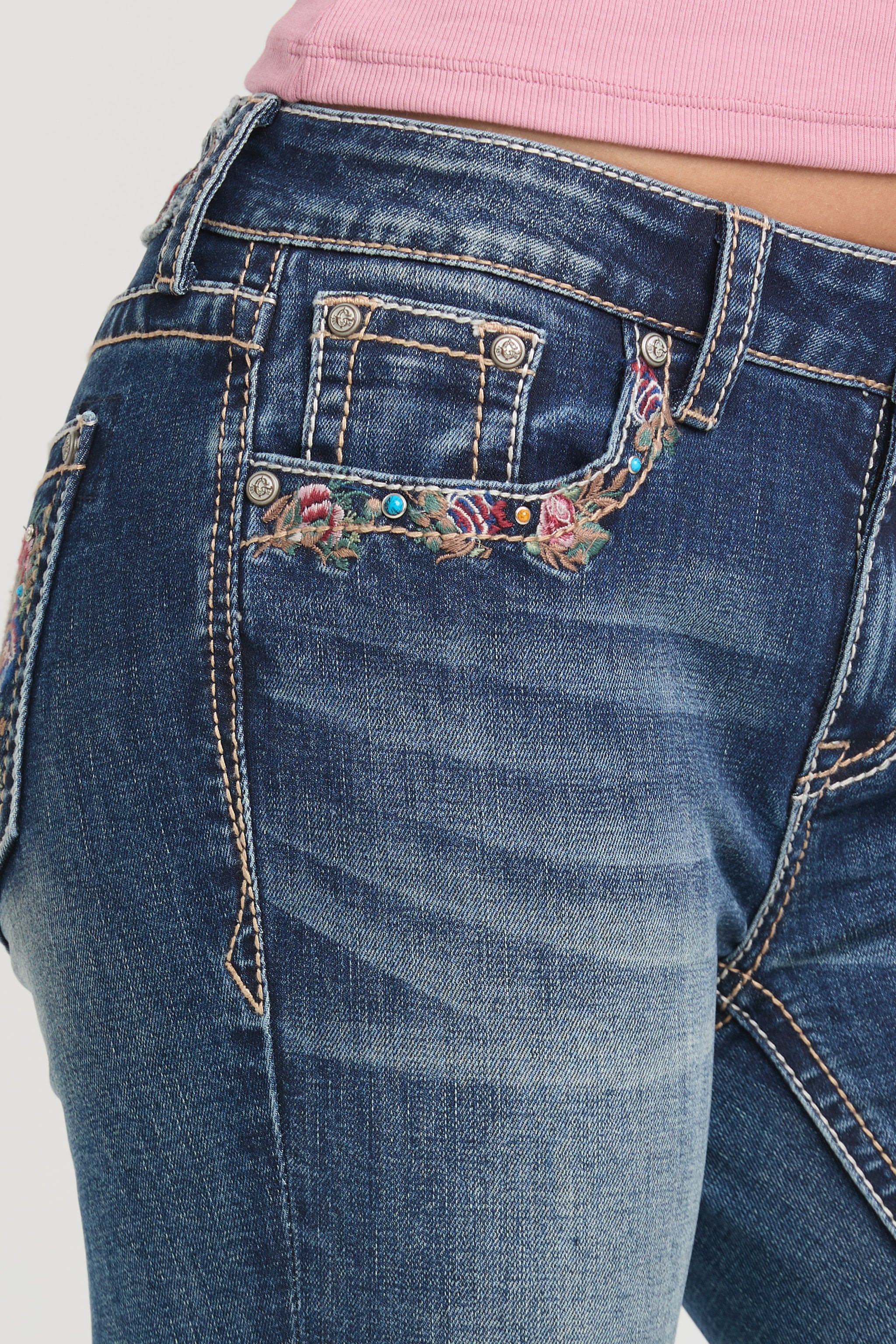 Womens bootcut jeans Close-up of the front hip featuring a colorful floral embroidered coin pocket on Grace in LA.