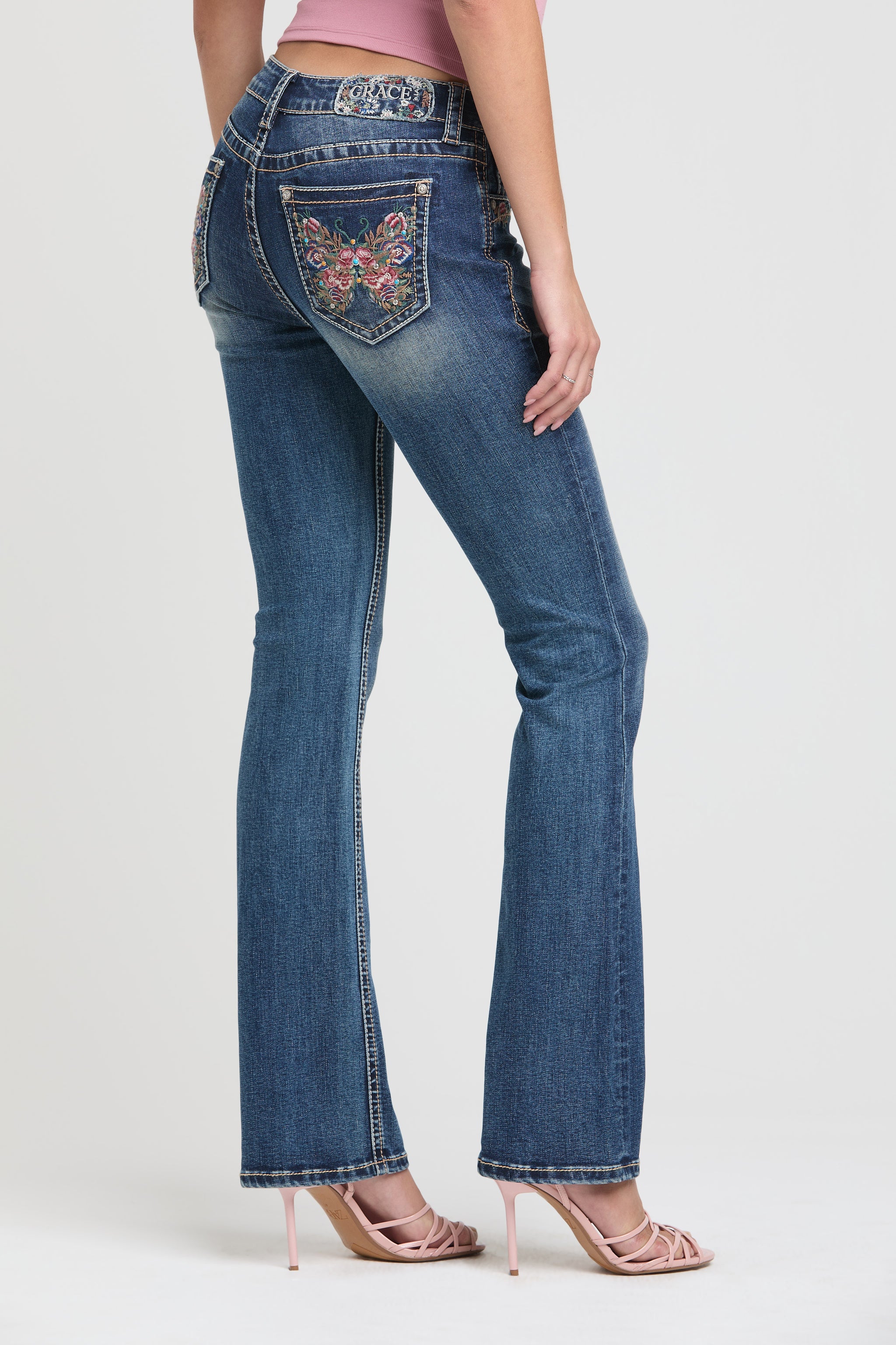 Grace in LA womens bootcut jeans Angled back view highlighting the embroidered butterfly pocket.