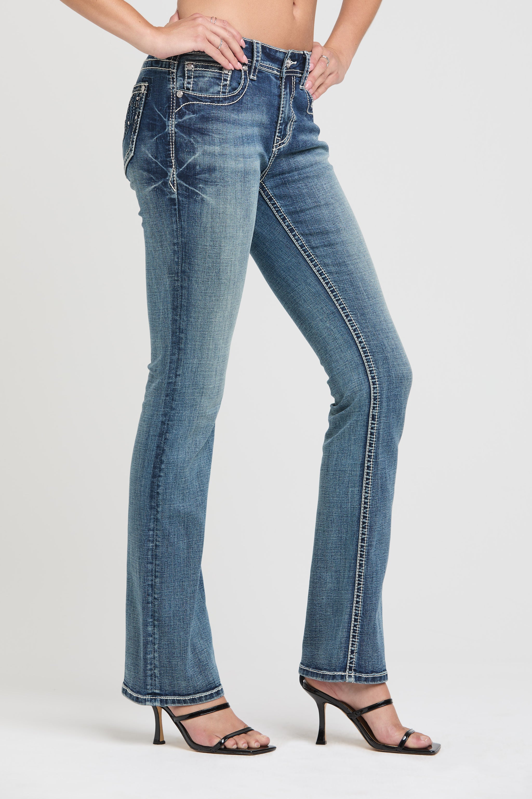 Grace in LA bedazzled jeans women in a faded light blue with ornate rhinestone pocket embellishments and a bootcut leg.
