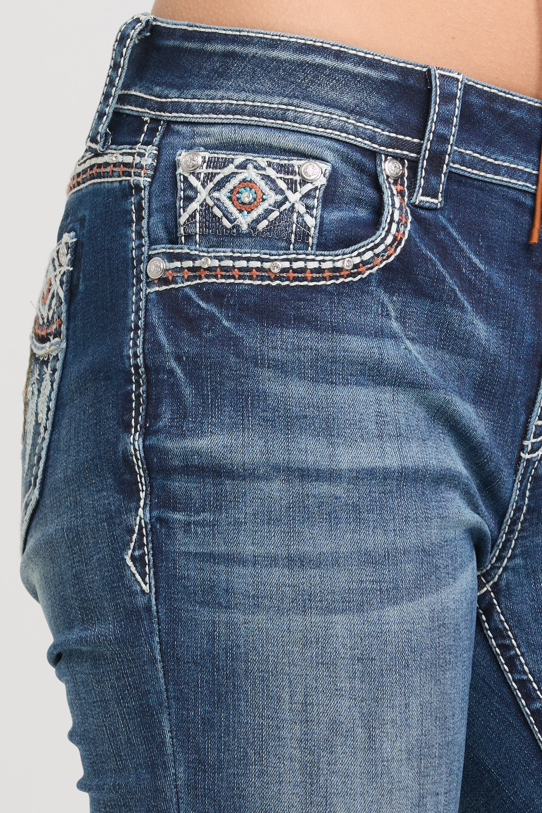 Grace in LA rhinestone jeans for women in a light featuring intricate white geometric embroidery and crystal studs on the back pockets.