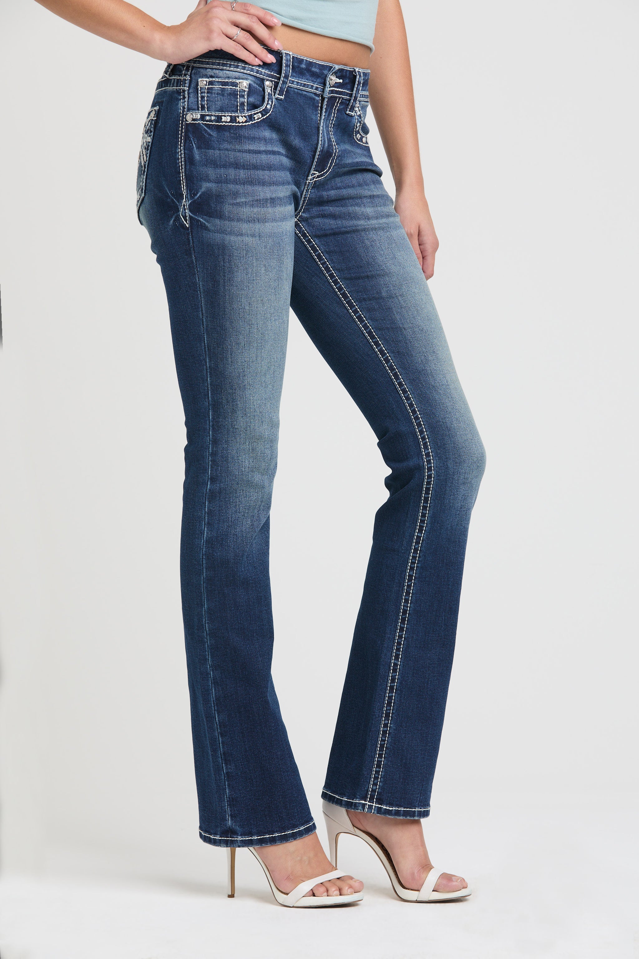 Grace in LA womens bootcut jeans in a dark wash, styled with heels against a clean white background to showcase the slim fit and western aesthetic.