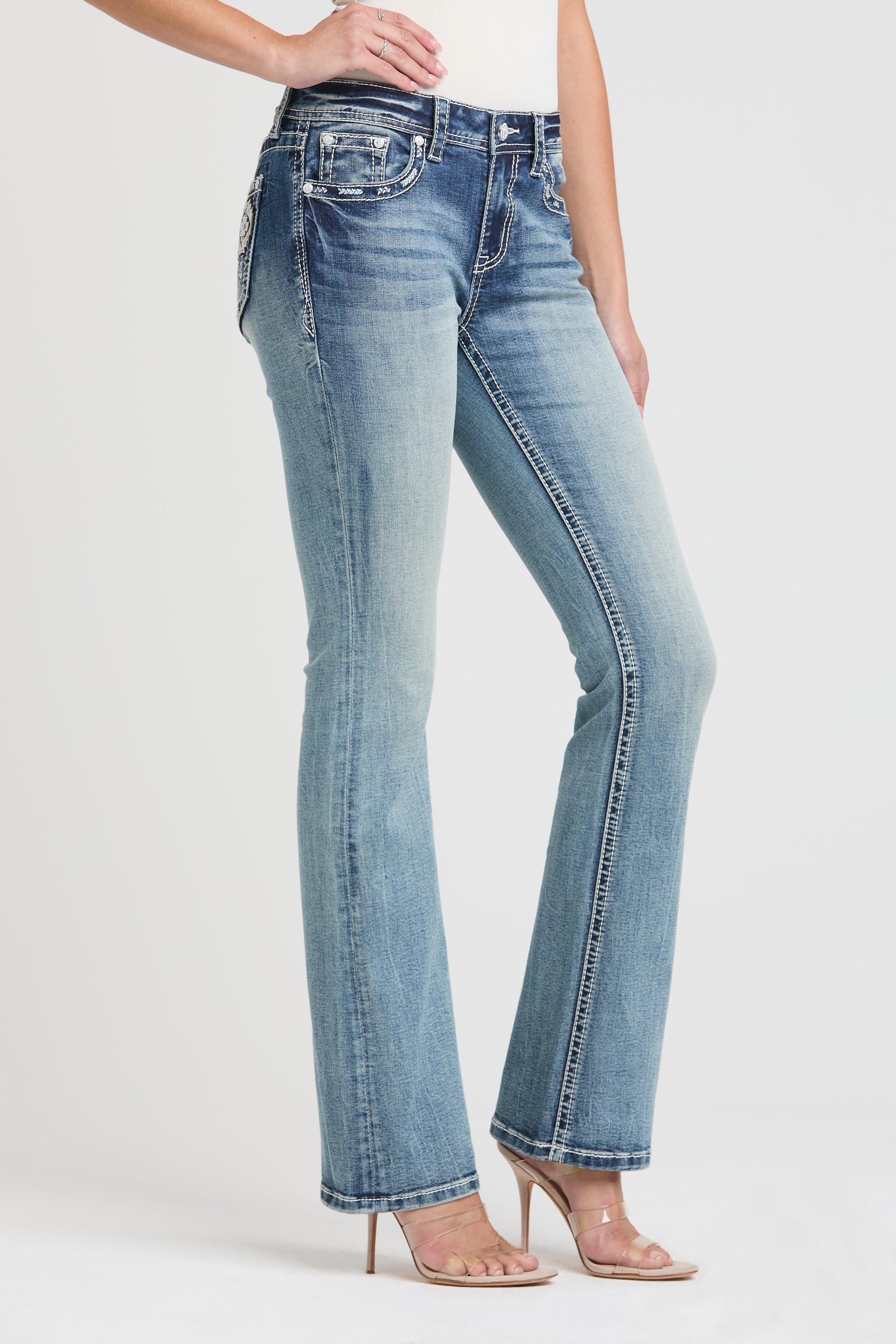 Side angle full-length view of Grace in LA womens flare jeans showcasing the light wash and leg shape.