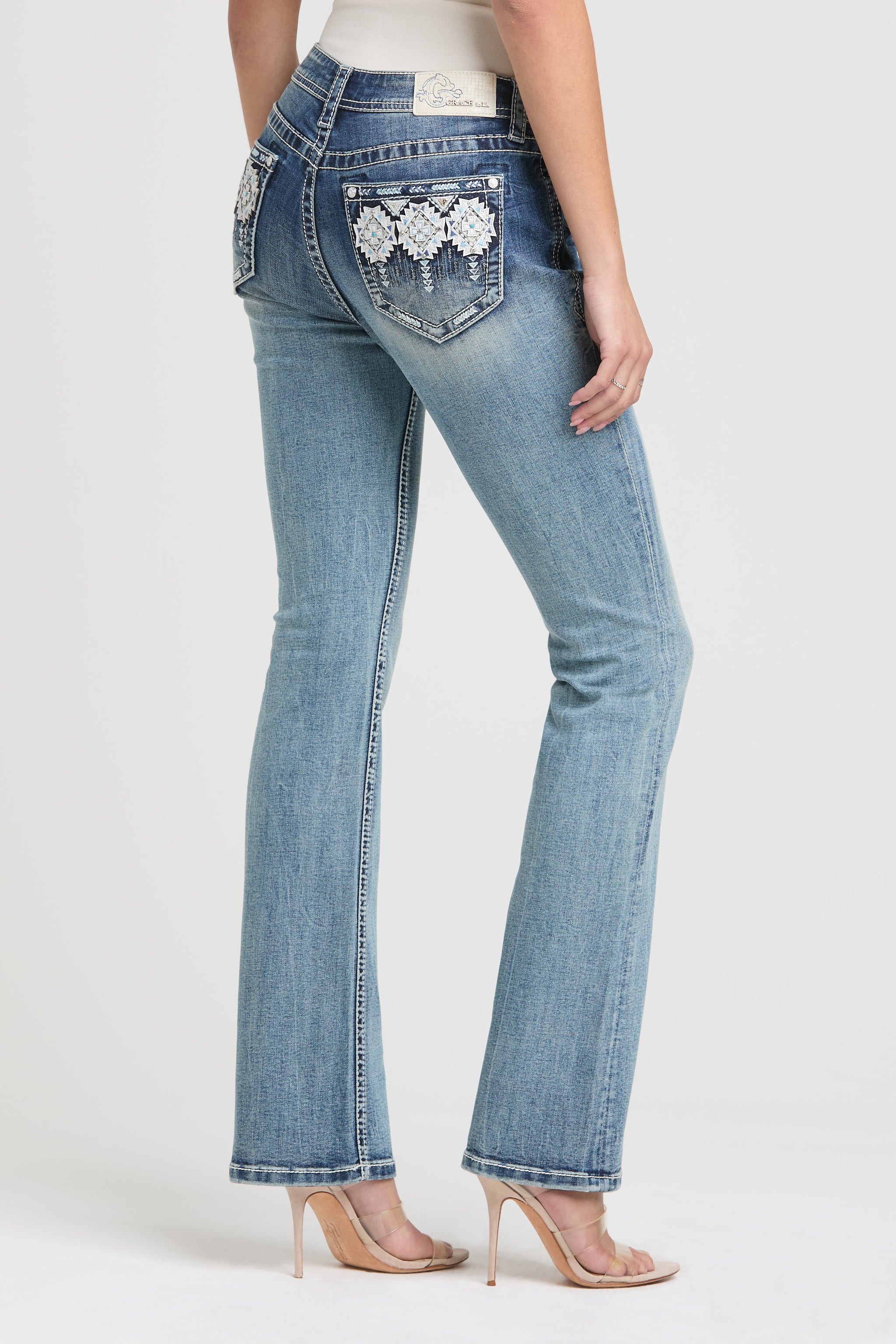 Back angle of Grace in LA womens flare jeans featuring white floral pocket embroidery.