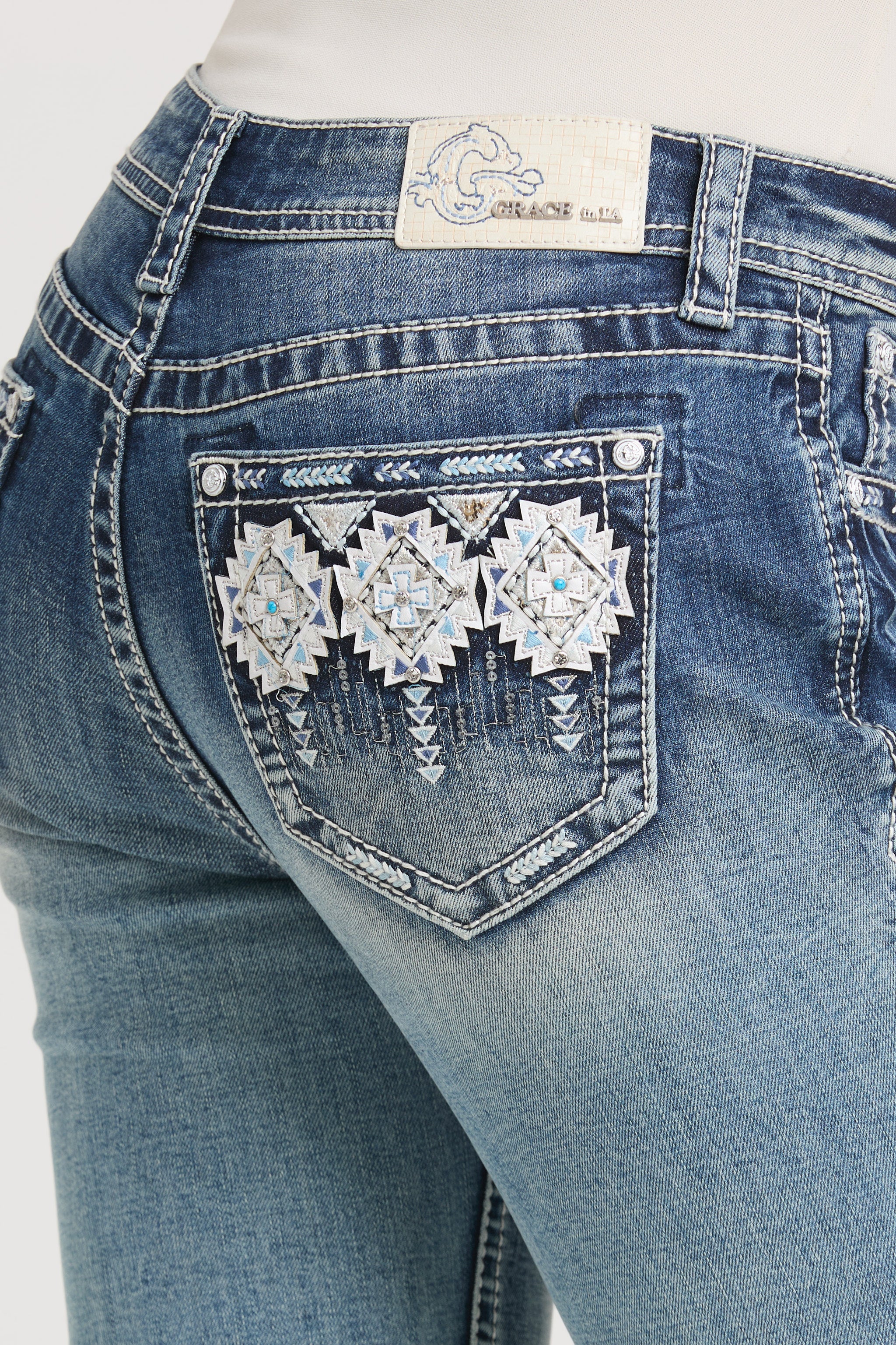 Close-up of back pocket detail on Grace in LA rhinestone jeans women featuring geometric silver embellishments.
