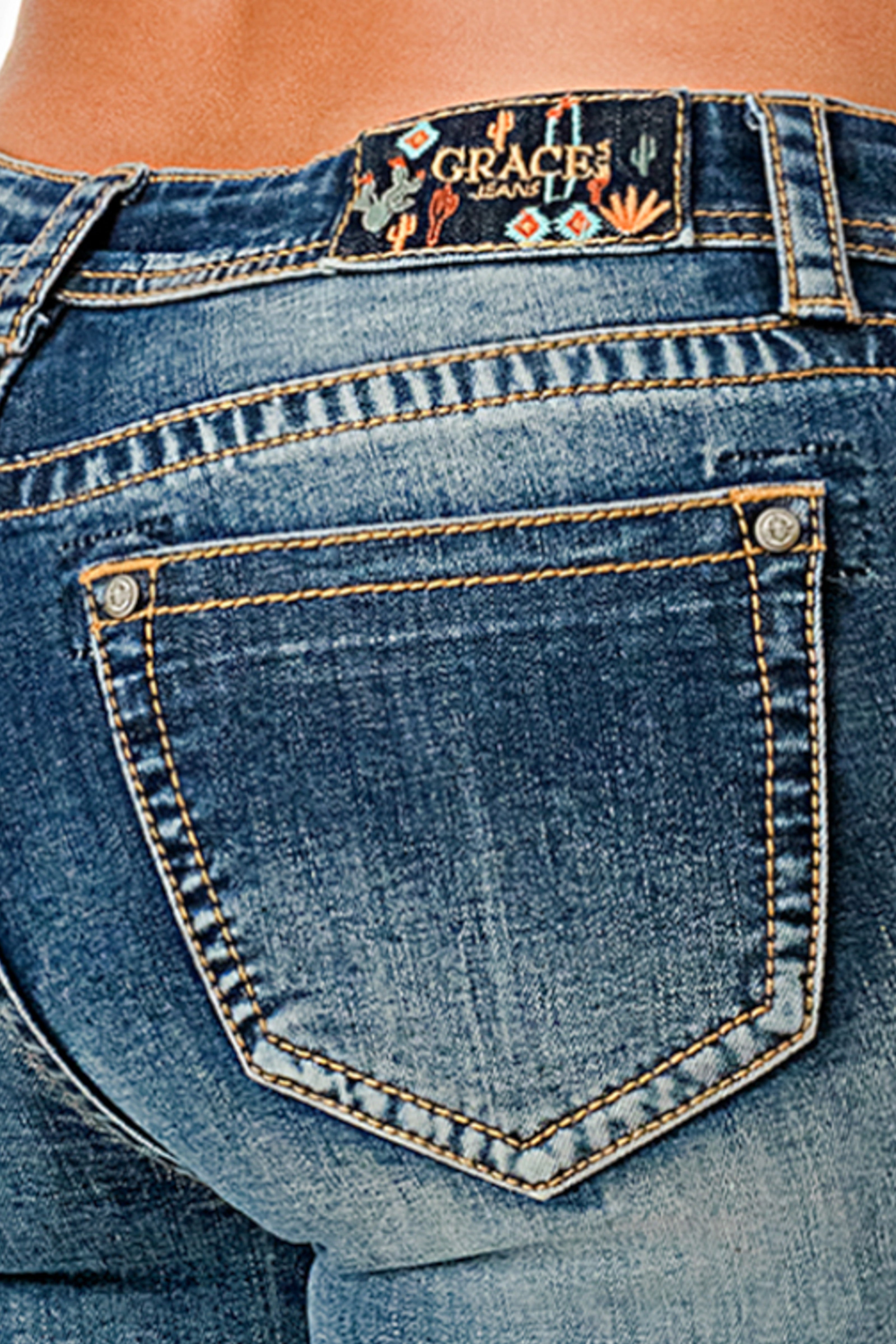 Grace in LA womens jeans featuring a dark wash with a decorative desert-themed brand patch on the waistband and clean back pockets.