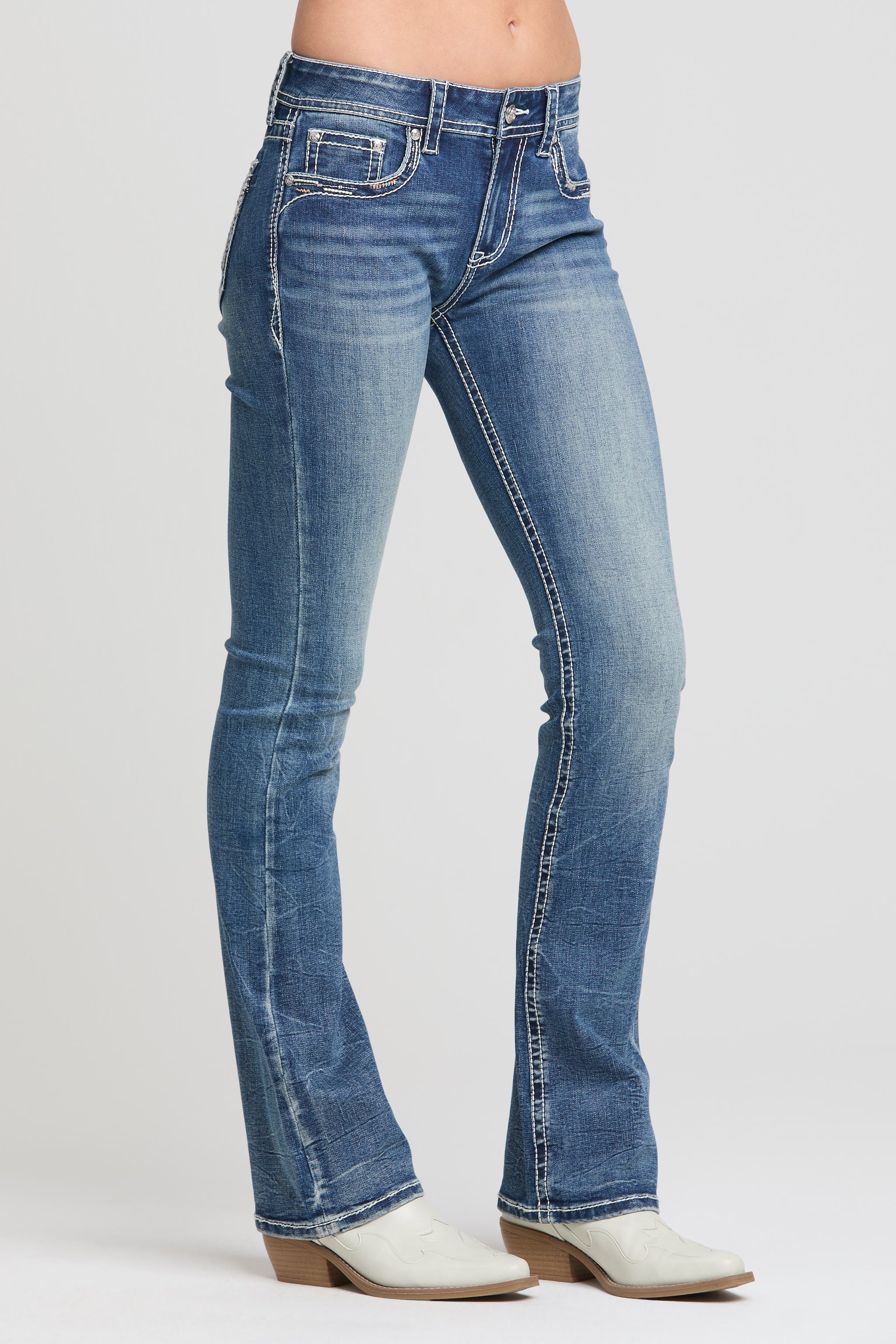 Grace in LA women’s medium wash low rise women bootcut jeans front angle with whiskering detail