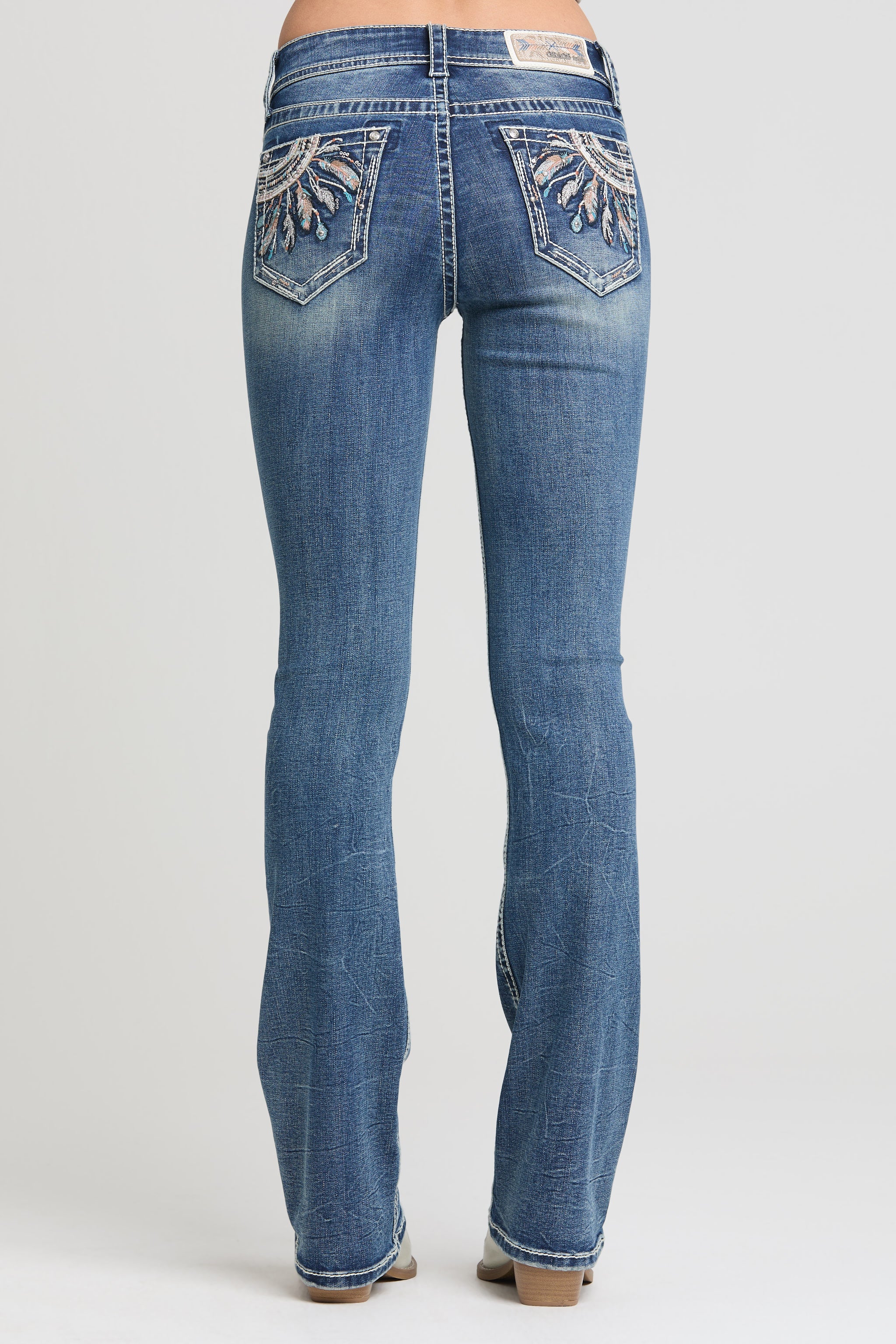 Grace in LA women’s medium wash bootcut jeans with feather embroidered back pockets full back view