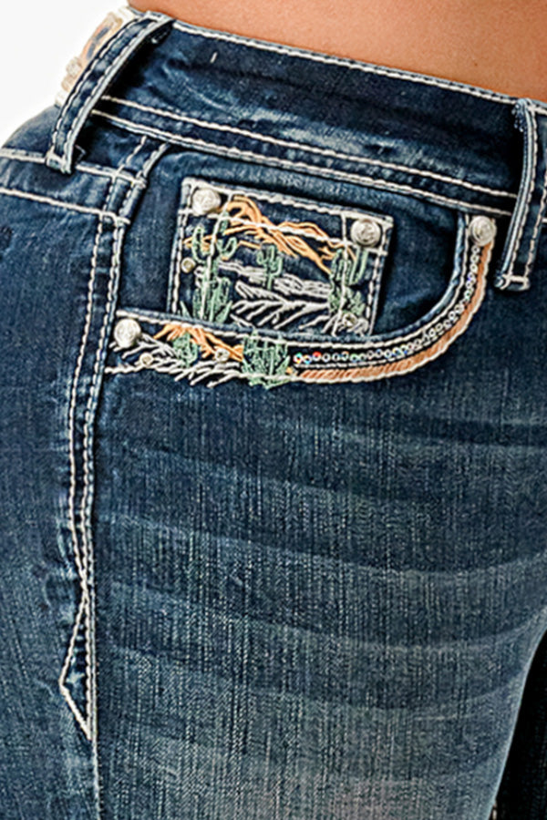 Grace in LA western jeans for women featuring a dark wash with desert cactus embroidery and colorful sunset-themed beadwork on the front hip pocket.