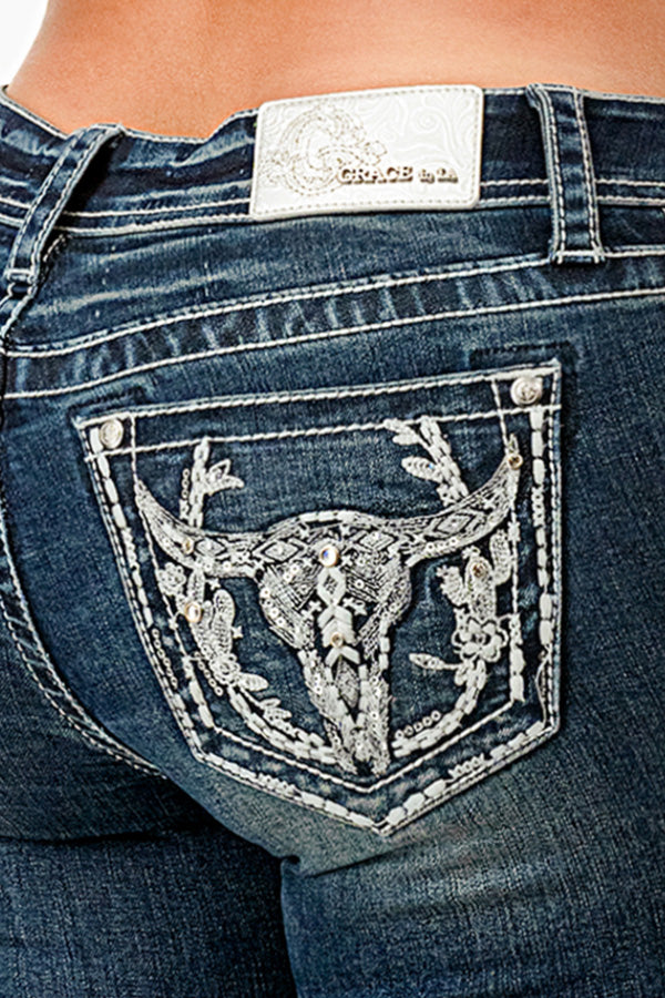 Grace in LA embroidered jeans women featuring a silver longhorn bull skull with floral antlers and rhinestone accents on the back pocket.