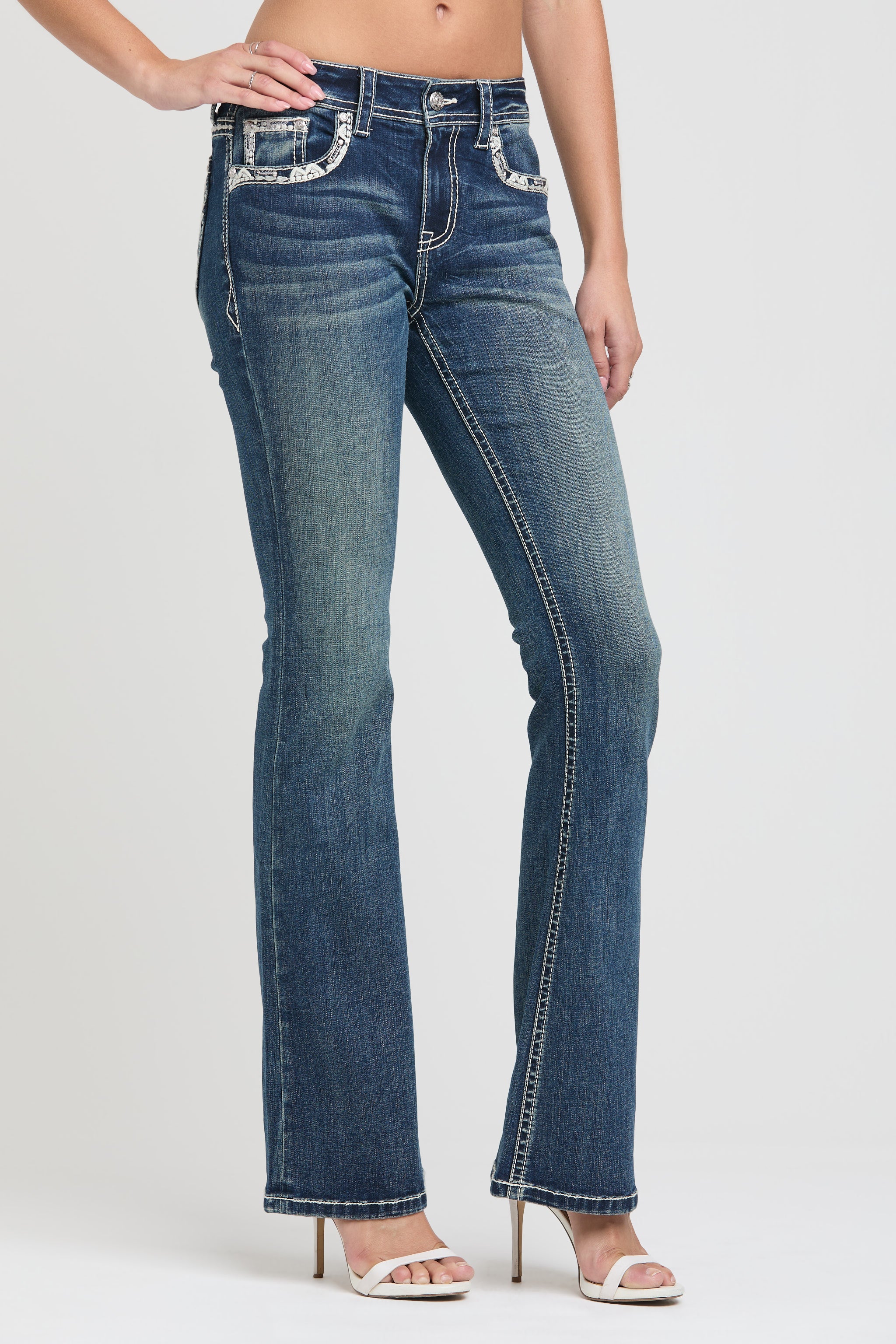 Grace in LA cowgirl jeans women in a dark indigo with unique copper button-front pocket detailing and a flare leg fit.