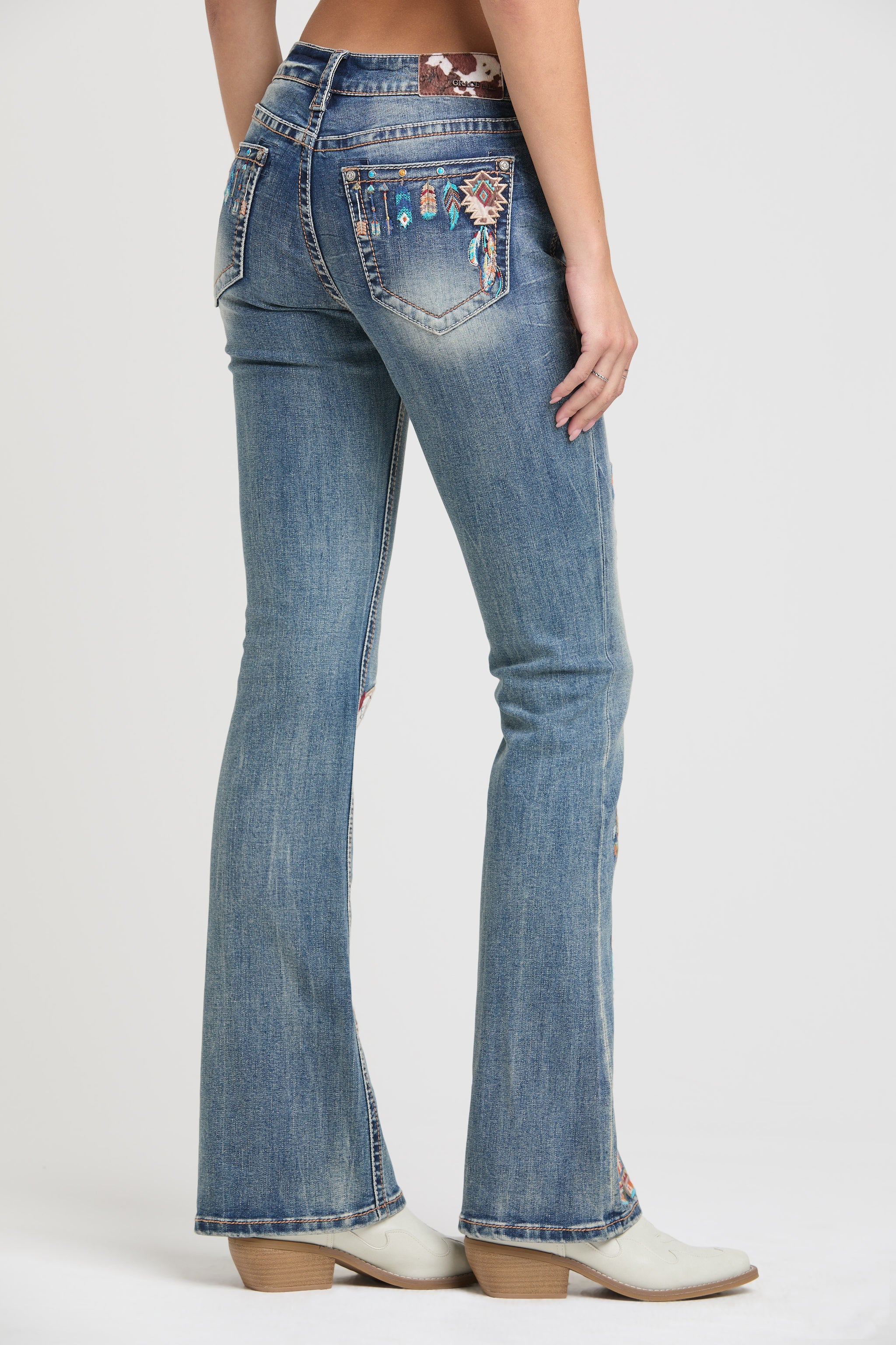 Grace in LA rhinestone jeans for women featuring colorful geometric tribal embroidery with crystal studs on the back pocket and waistband.