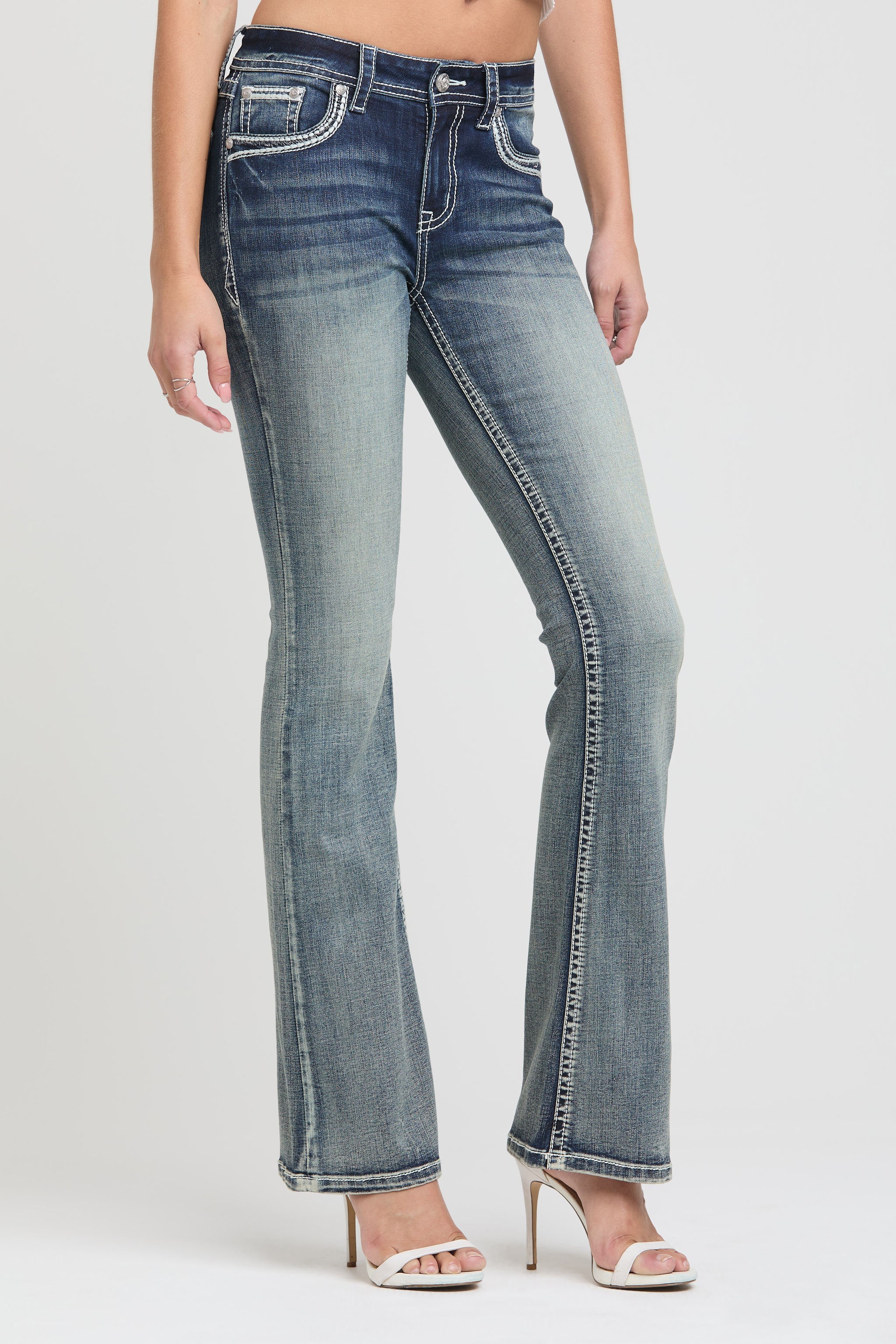 Grace in LA women's acid wash jeans in a bootcut fit featuring thick white contrast stitching and silver hardware accents on the front pockets.