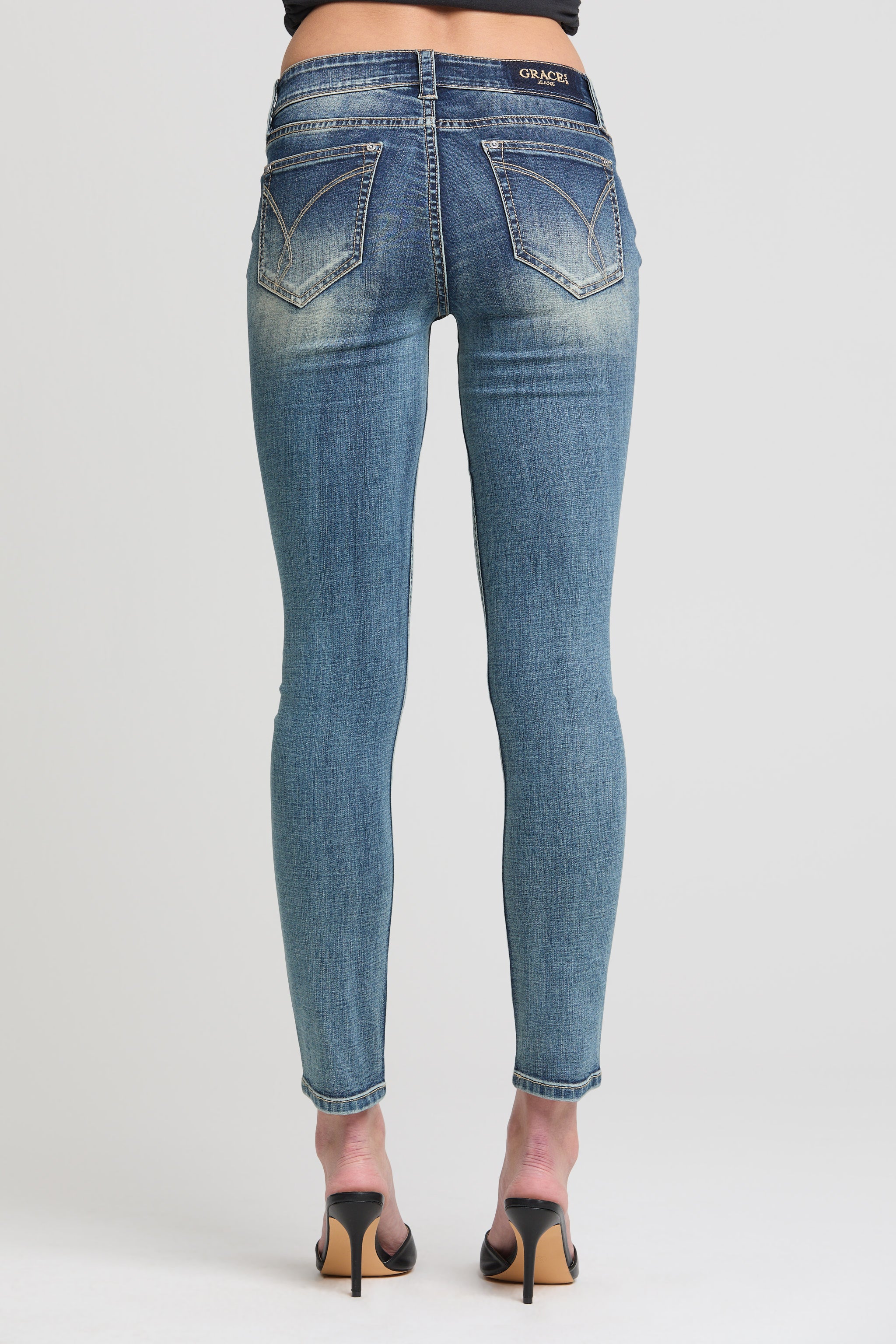 Grace in LA women’s acid wash skinny jeans back view with curved pocket stitching and faded detail