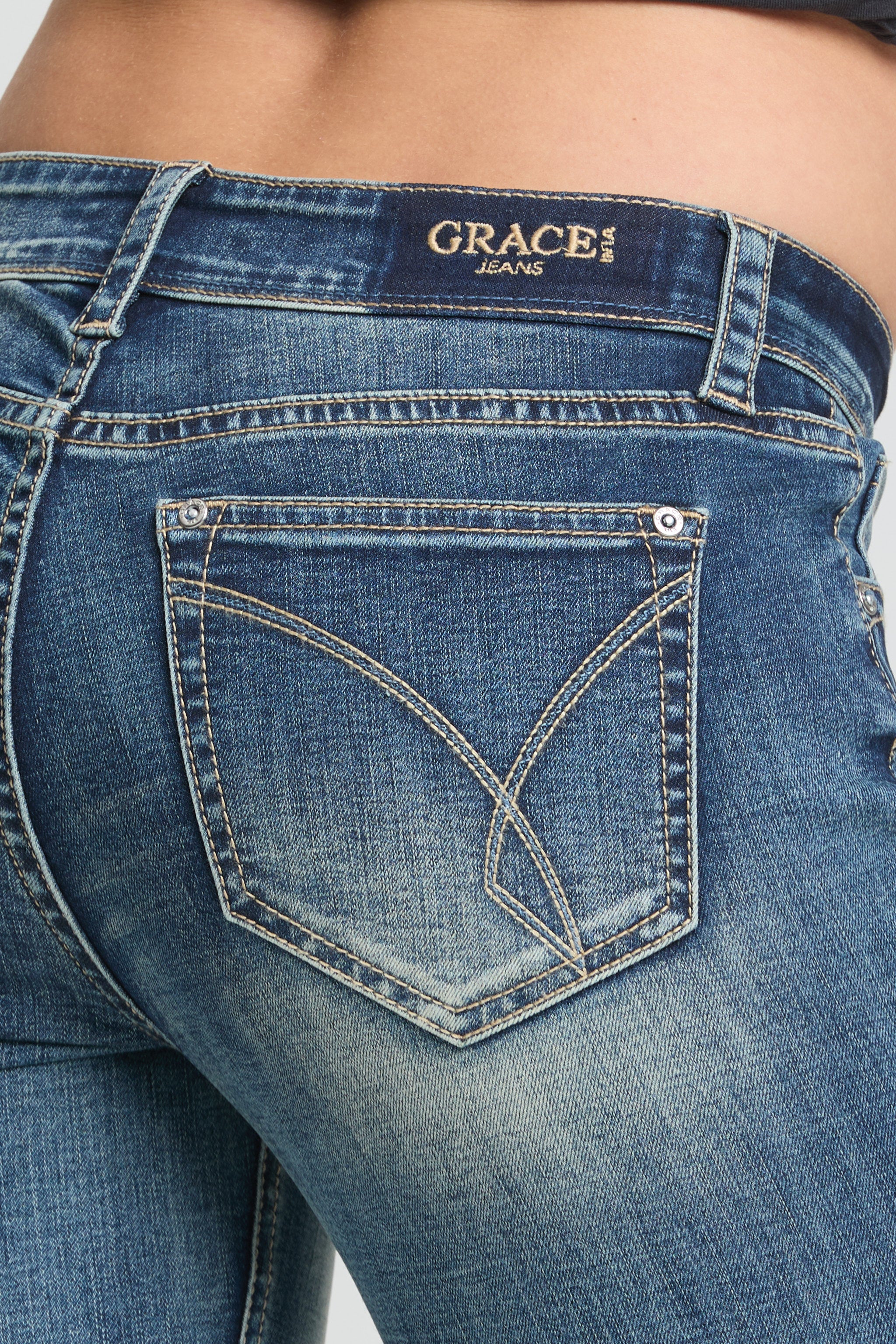 Grace in LA women’s medium wash low rise bootcut jeans back pocket close up with signature stitching