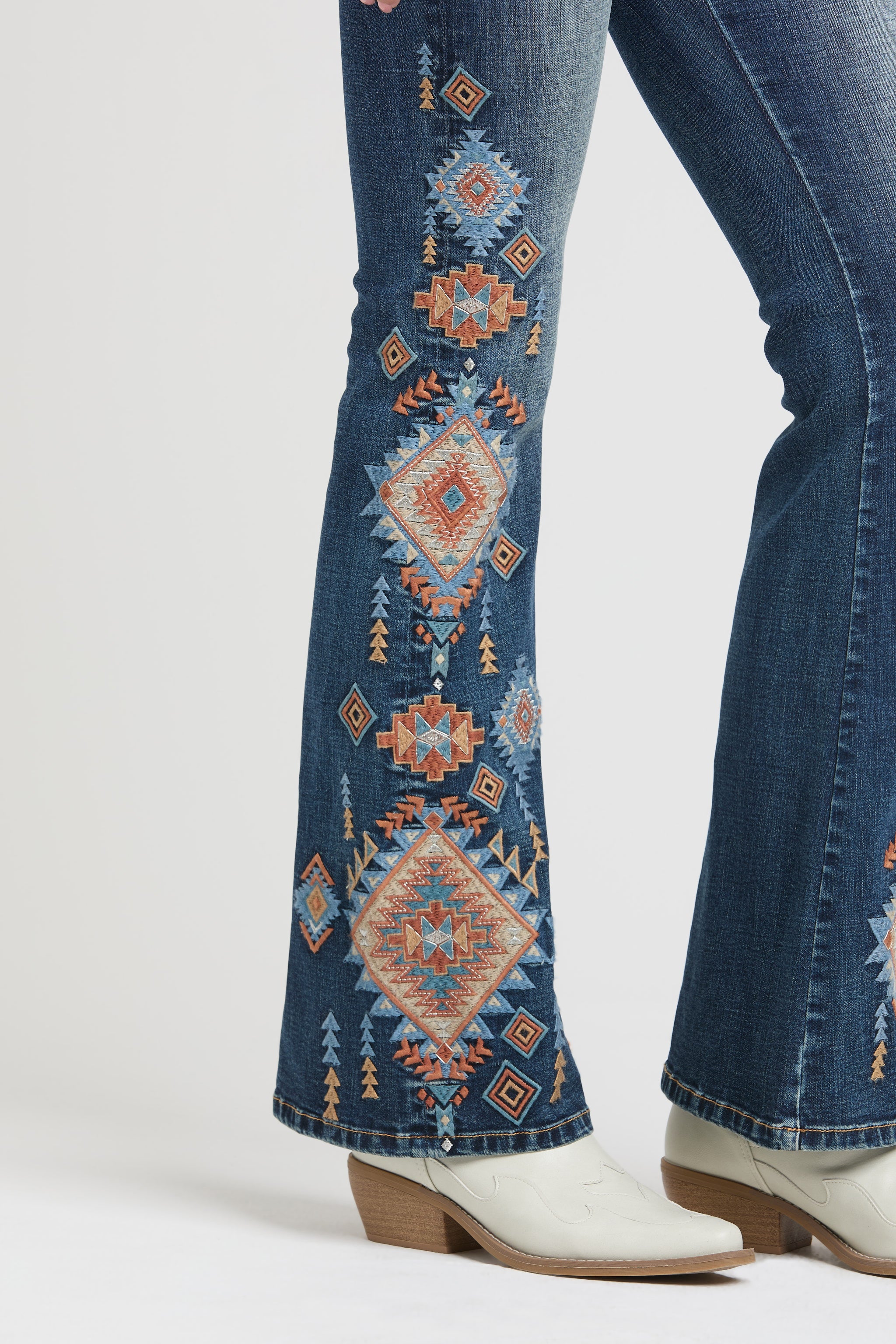 Grace in LA rhinestone jeans for women featuring colorful geometric tribal embroidery across the back yoke and pockets with crystal accents.