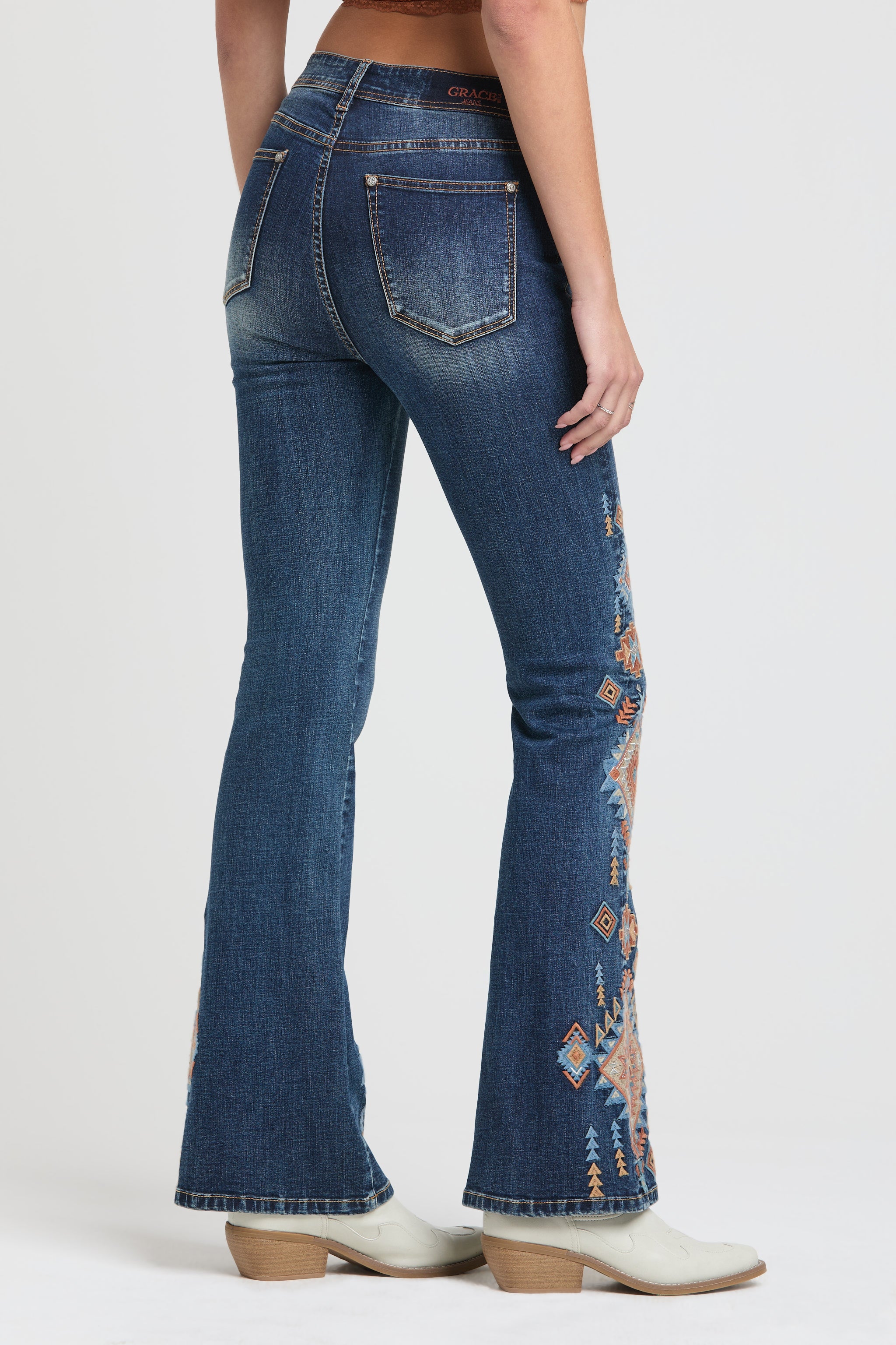 Grace in LA womens flare jeans featuring a multi-colored geometric tribal pattern embroidered on the side of the leg.