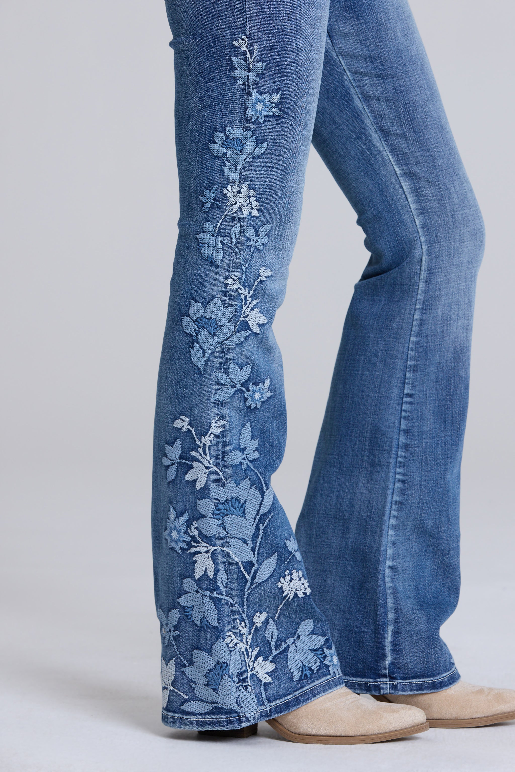 Grace in LA women's medium wash floral embroidered flare jeans, front-facing view with boho-inspired embroidery detailing