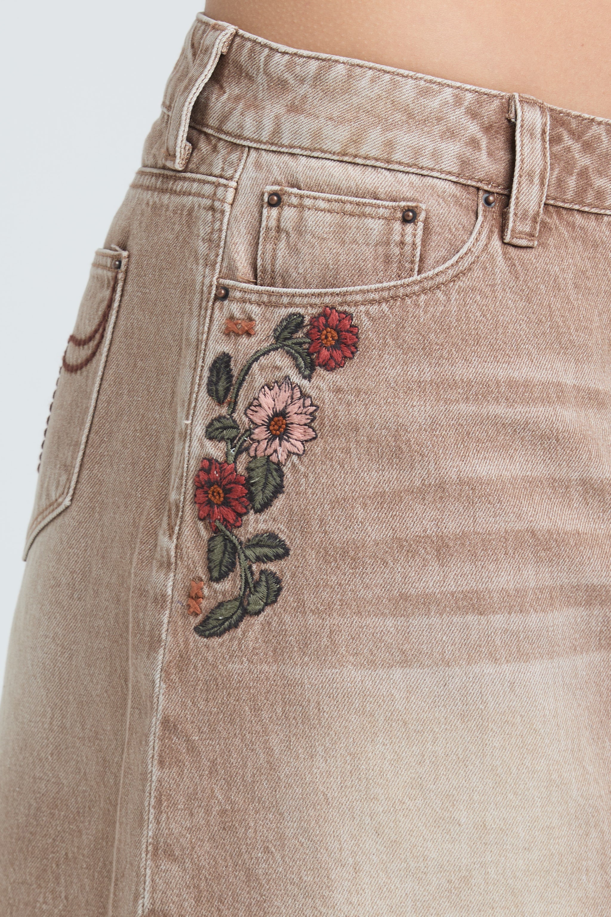 Grace in LA beige denim shorts with red and pink floral embroidery on the front hip pocket.
