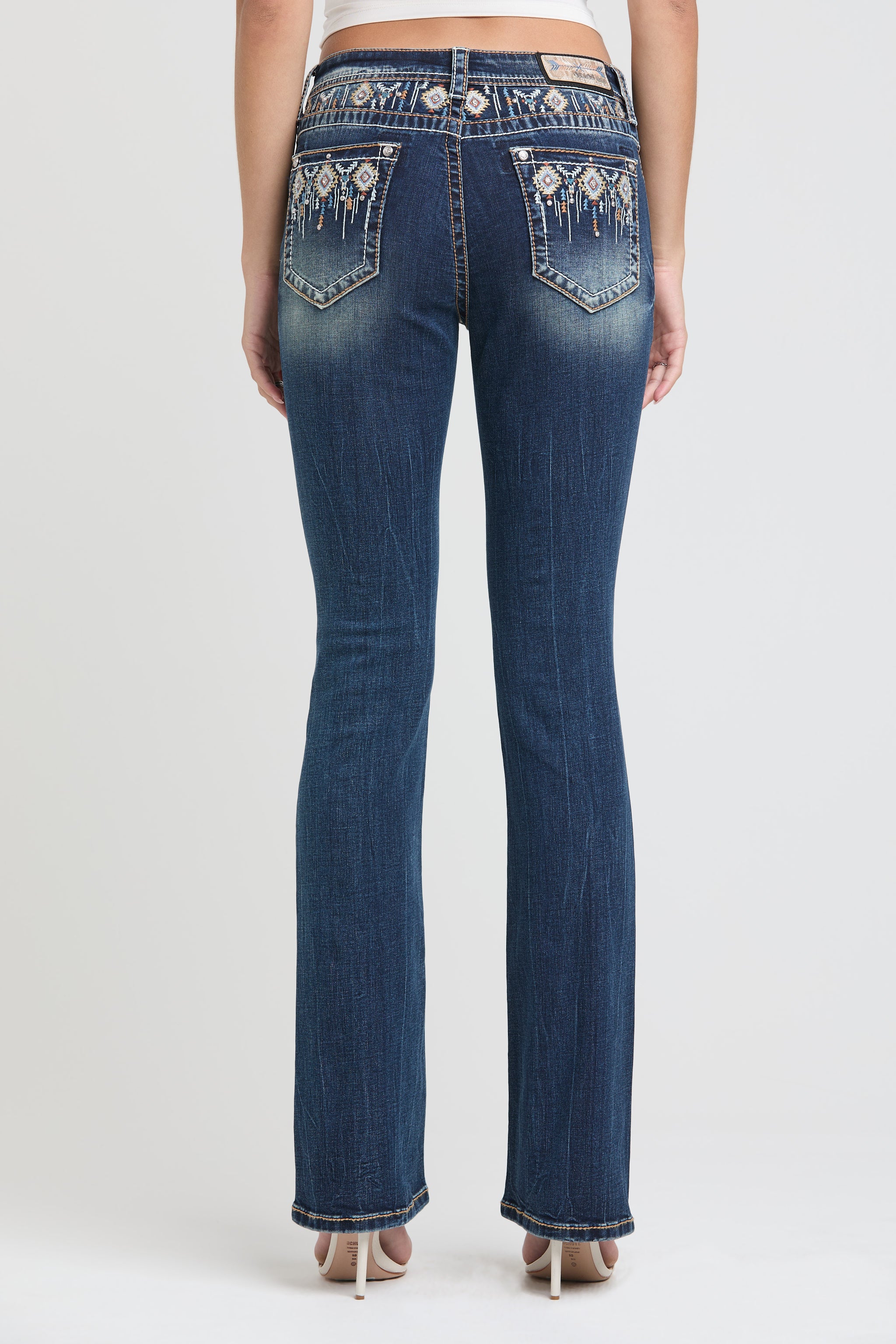 Grace in LA womens bootcut jeans in a medium featuring western-inspired white floral lace embroidery and rhinestone accents on the back pockets.
