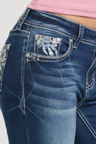 Grace in LA embroidered jeans women featuring an ornate silver horseshoe motif on the back pocket with intricate white floral patterns and crystal rhinestone accents.