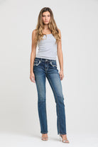 Grace in LA womens bootcut jeans in a dark wash, styled with a light gray tank top to highlight the slim fit and turquoise cross embroidery.