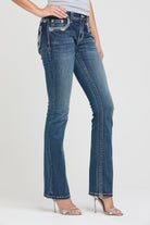 Grace in LA womens bootcut jeans in a dark wash, styled with heels against a white background to showcase the slim fit and turquoise accented western design.