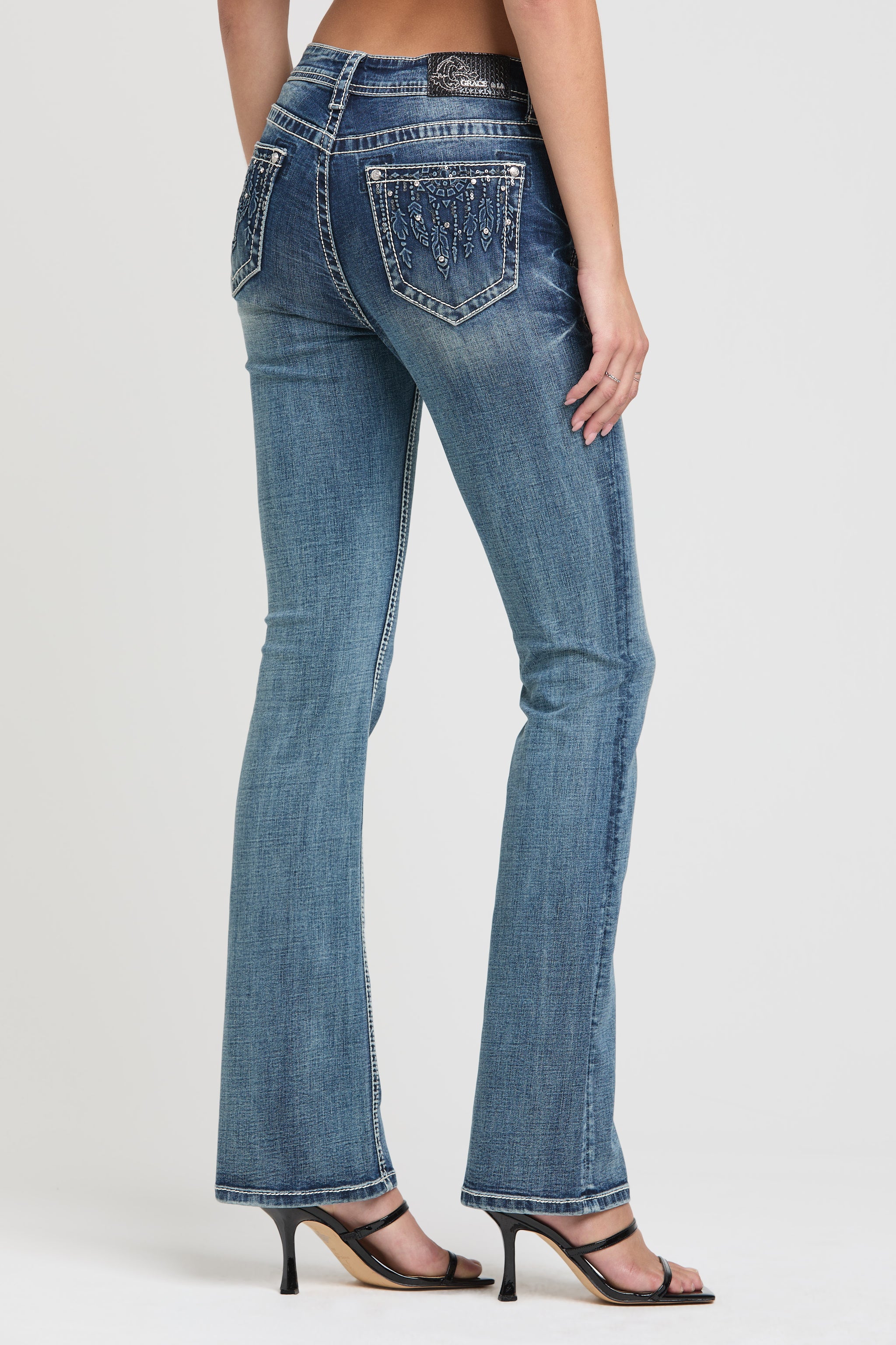 Grace in LA womens bootcut jeans in light wash with side view of sparkly rhinestone and sequin embellished pockets.