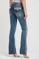 Grace in LA embroidered jeans women featuring a vertical white lace-inspired floral pattern along the outer side seam.