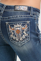 Grace in LA embroidered jeans women featuring a western longhorn bull skull motif with copper-colored horns and a tribal geometric star on the back pocket.