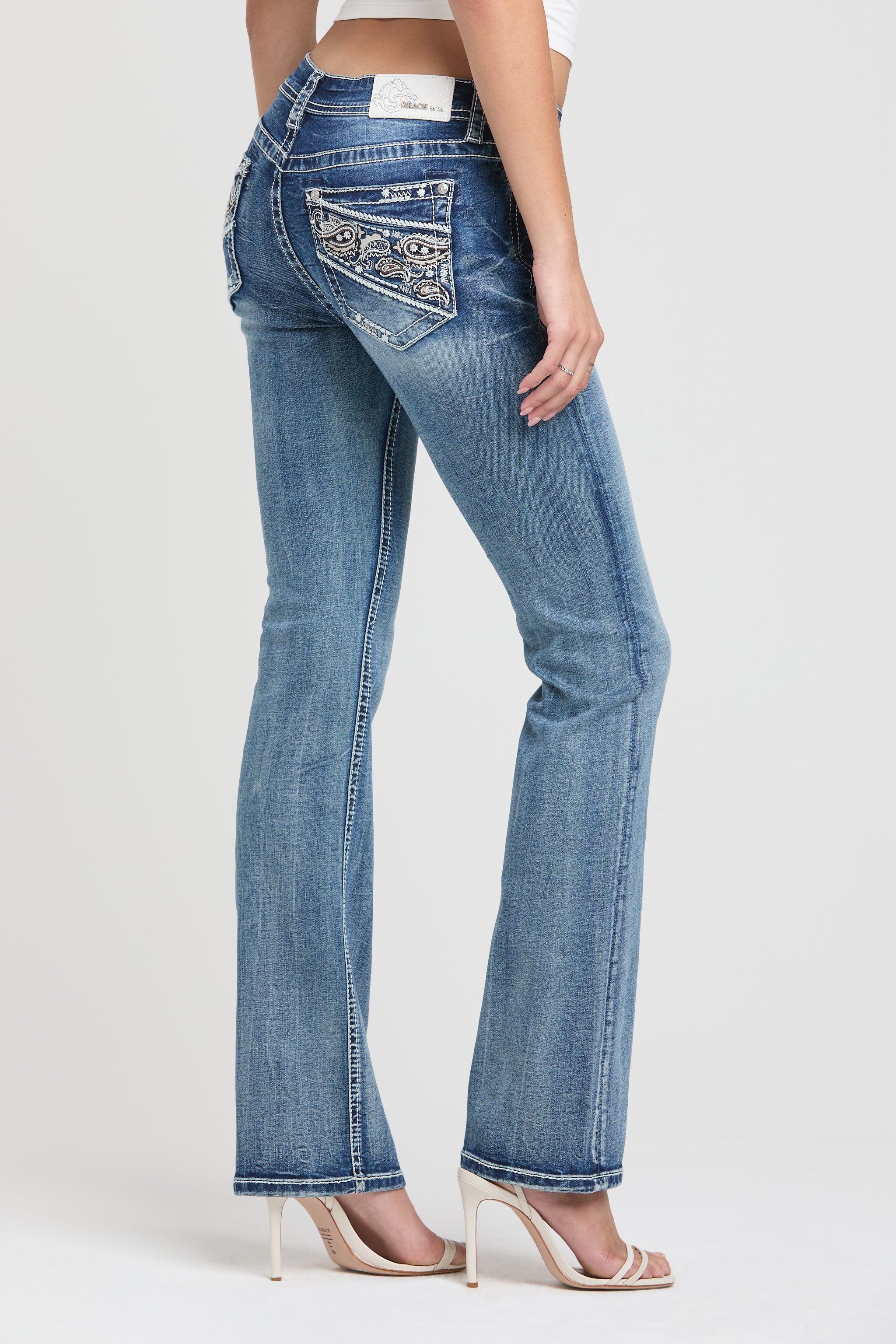 Grace in LA embroidered jeans women featuring a western paisley design with a mix of neutral and metallic stitching on the back pocket.