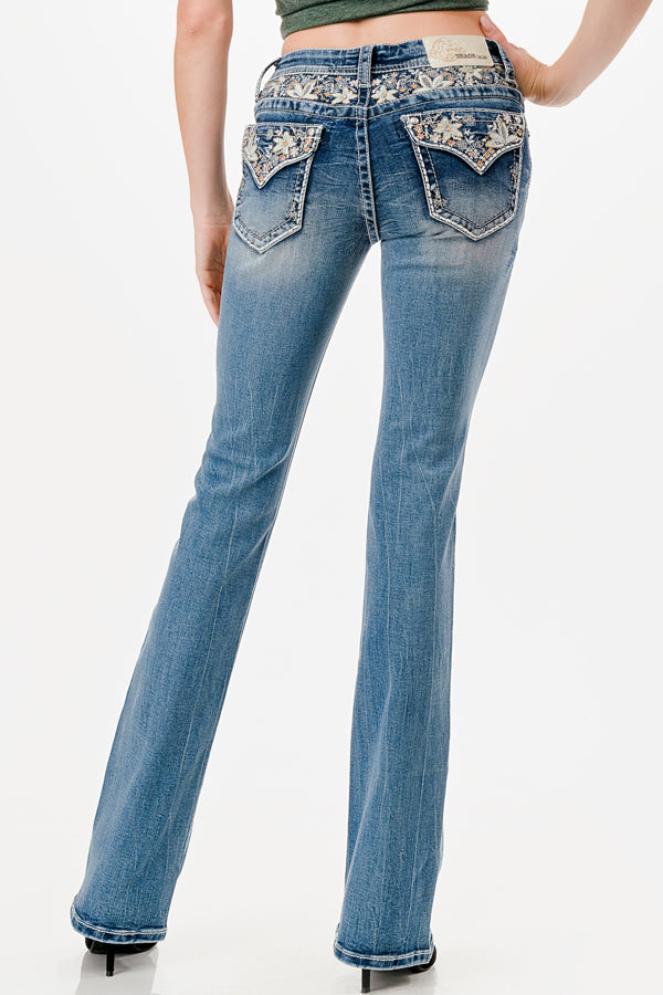 Grace in LA embroidered jeans women featuring a vibrant cream and gold floral vine pattern across the back yoke and flap pockets with a white leather brand patch.