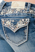 Grace in LA embroidered jeans women featuring a vibrant pastel floral yoke and flap pocket design with a branded cream leather waist patch.