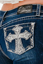 Grace in LA western jeans for women featuring a large silver rhinestone cross patch and intricate embroidery on the back pocket.