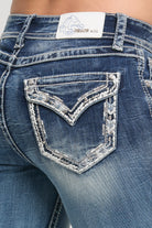 Grace in LA women's medium light wash mid-rise bootcut jeans, front-facing view with border stitches design