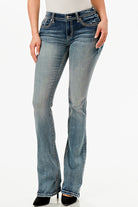 Grace in LA embroidered jeans women featuring a large silver fleur-de-lis motif with a blue geometric center and crystal rhinestone accents on the back pocket.