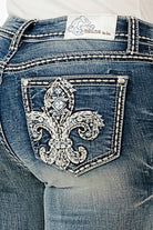 Grace in LA embroidered jeans women featuring a large silver and white fleur-de-lis design with light blue rhinestone centers on the back pocket.