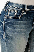 Grace in LA embroidered jeans women featuring a circular dreamcatcher coin pocket design with vibrant orange accents and hanging feather embroidery.