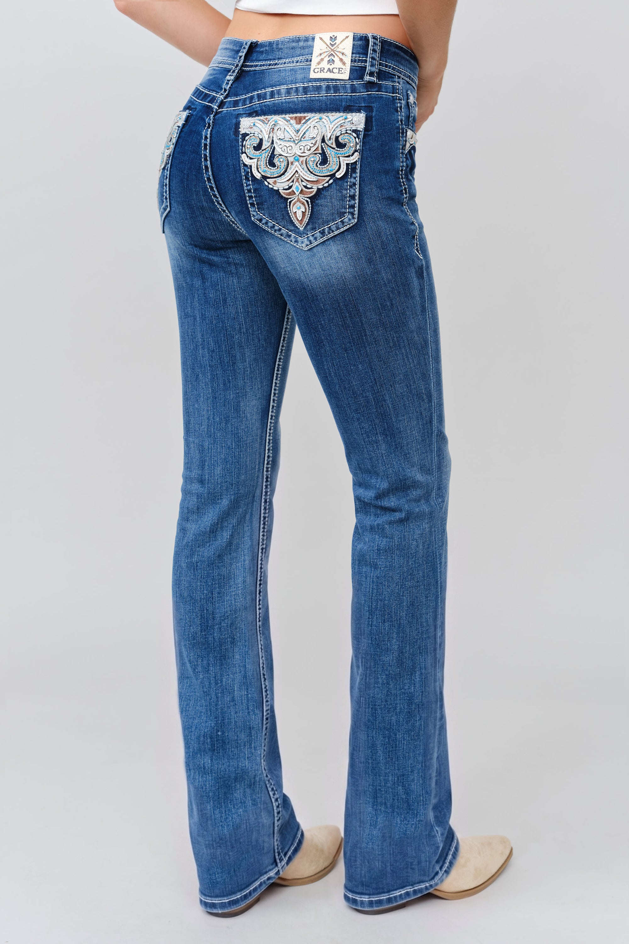 Grace in LA bootcut jeans close-up of Aztec ornate scrollwork appliqué and turquoise stone detailing