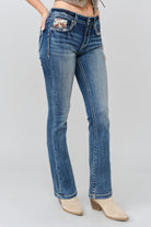 Grace in LA women's medium wash bootcut jeans styled with boots, steer head embroidery detail