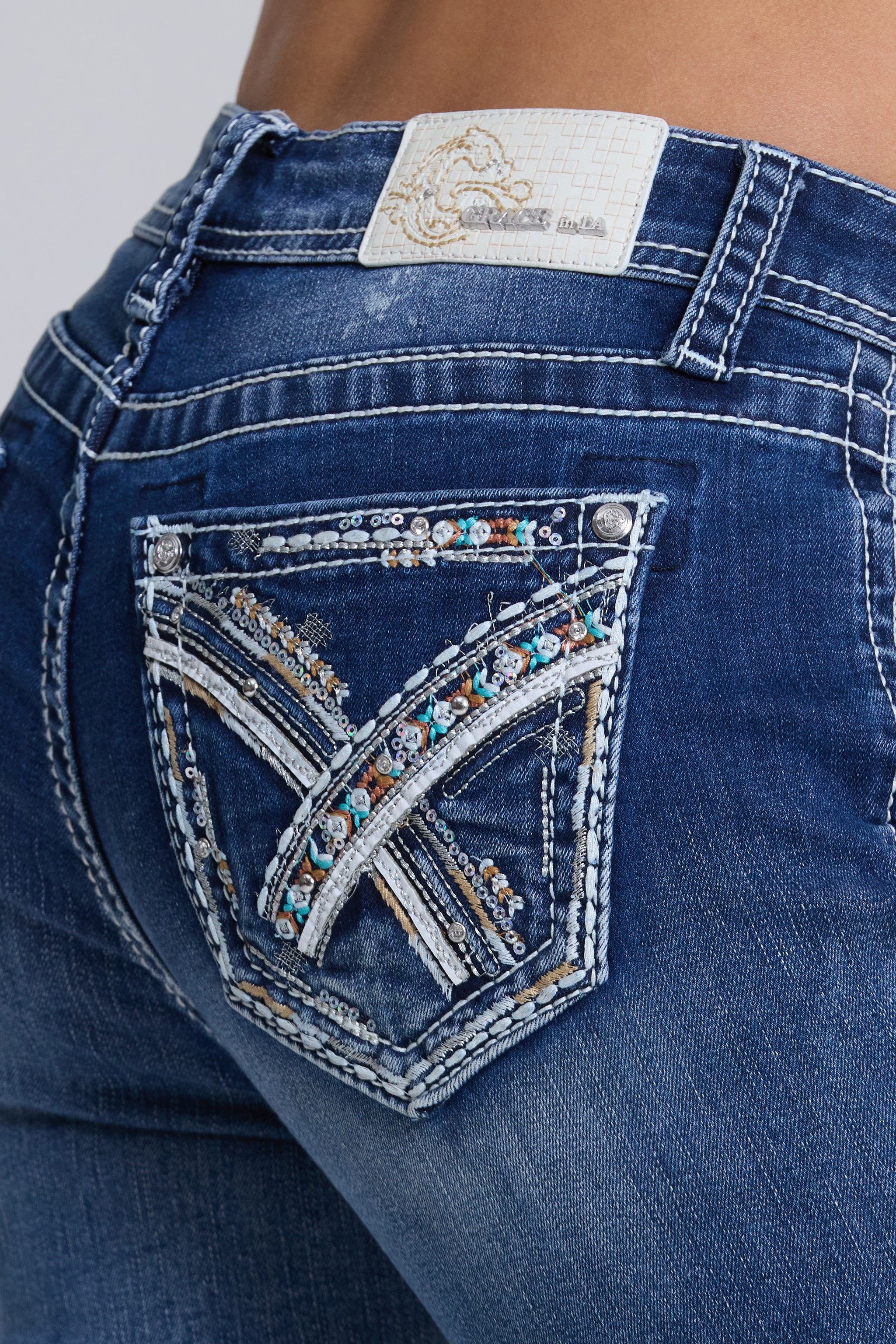 Grace in LA women's medium wash mid-rise capri jeans in a slim easy fit silhouette with geometric embroidery down the leg
