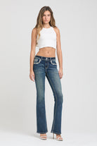 Grace in LA womens bootcut jeans in a distressed medium blue featuring intricate silver rhinestone and metallic thread pocket embroidery.