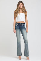 Grace in LA women's acid wash jeans in a slim bootcut fit, styled with a white tank top and heels against a clean white background.