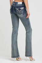 Grace in LA women's acid wash jeans in a slim bootcut fit featuring metallic silver wing embroidery and crystal accents on the back pockets.